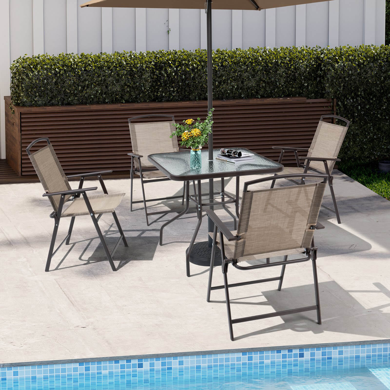 5-piece patio dining set with umbrella and folding chairs set up on a poolside deck.