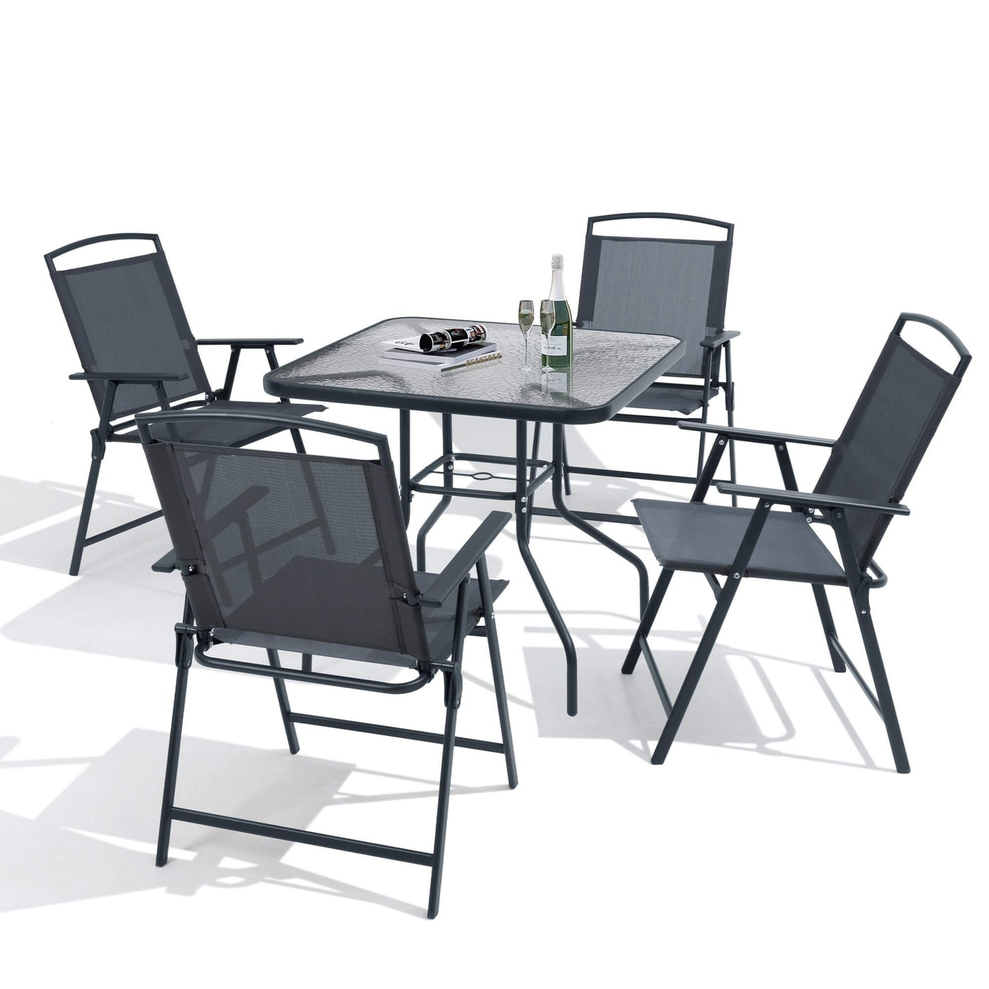 5-piece dark gray patio dining set with glass top table and folding chairs on white background.