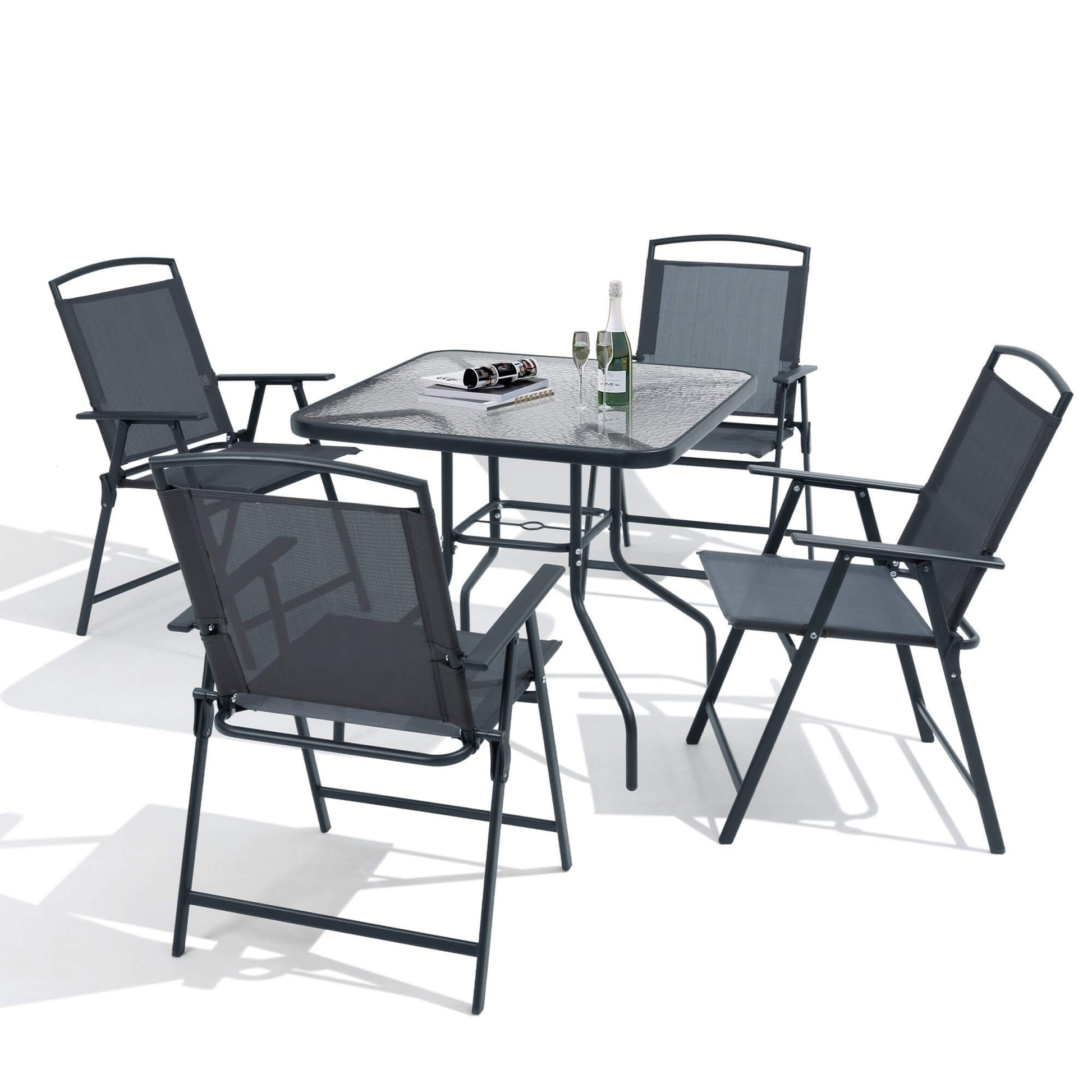 5-piece dark gray patio dining set with glass top table and folding chairs on white background.