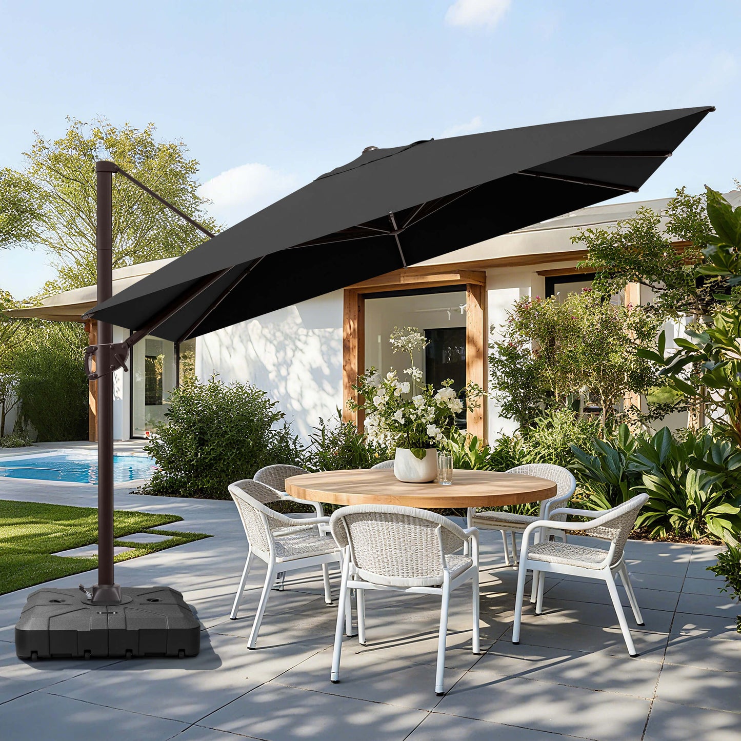 Black rectangular cantilever umbrella with wheeled base over patio dining set.