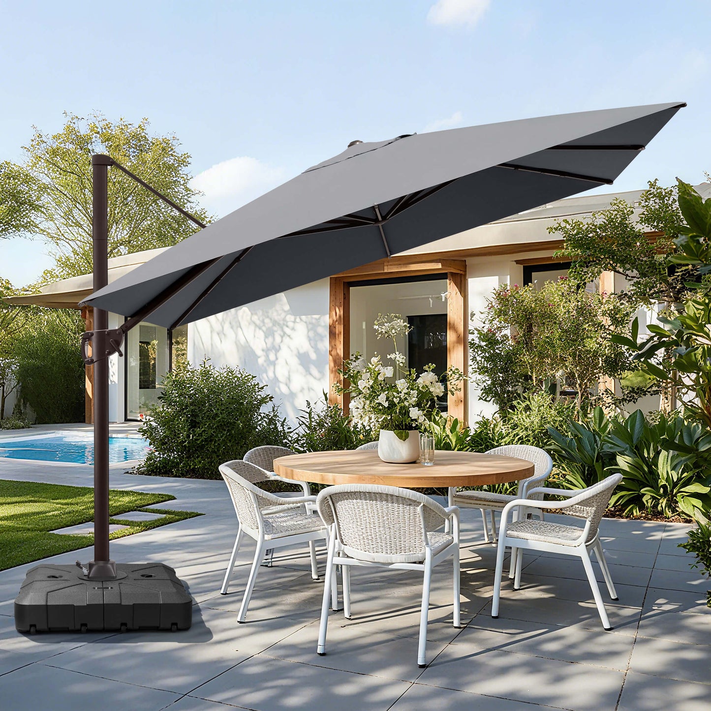 Grey rectangular cantilever umbrella with wheeled base over patio dining set.