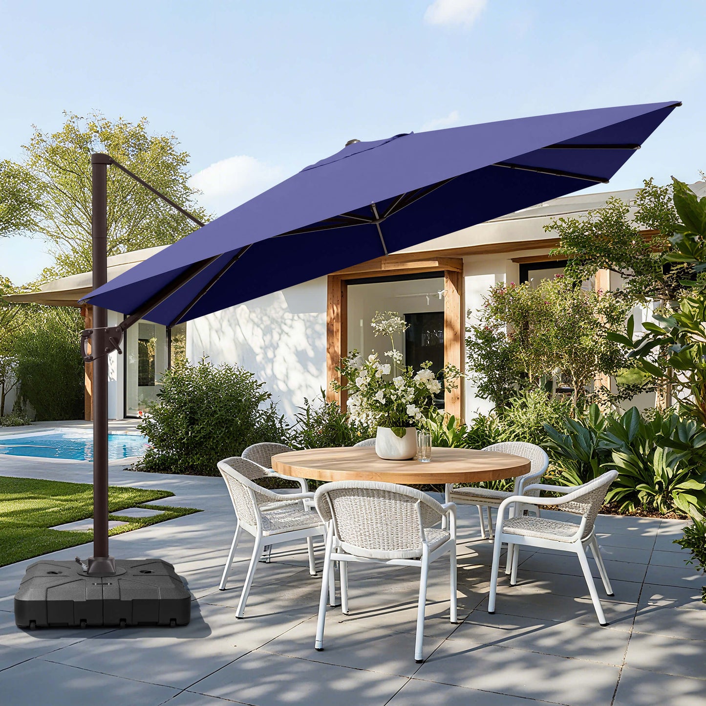 Navy blue rectangular cantilever umbrella with wheeled base over patio dining set.