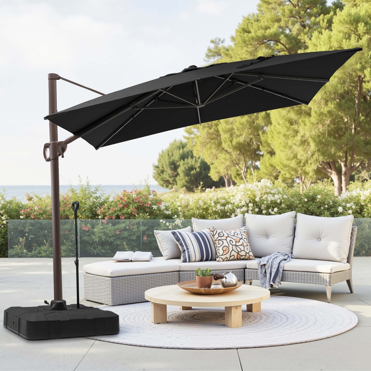 Black rectangular cantilever umbrella with pull-rod base over patio lounge seating.