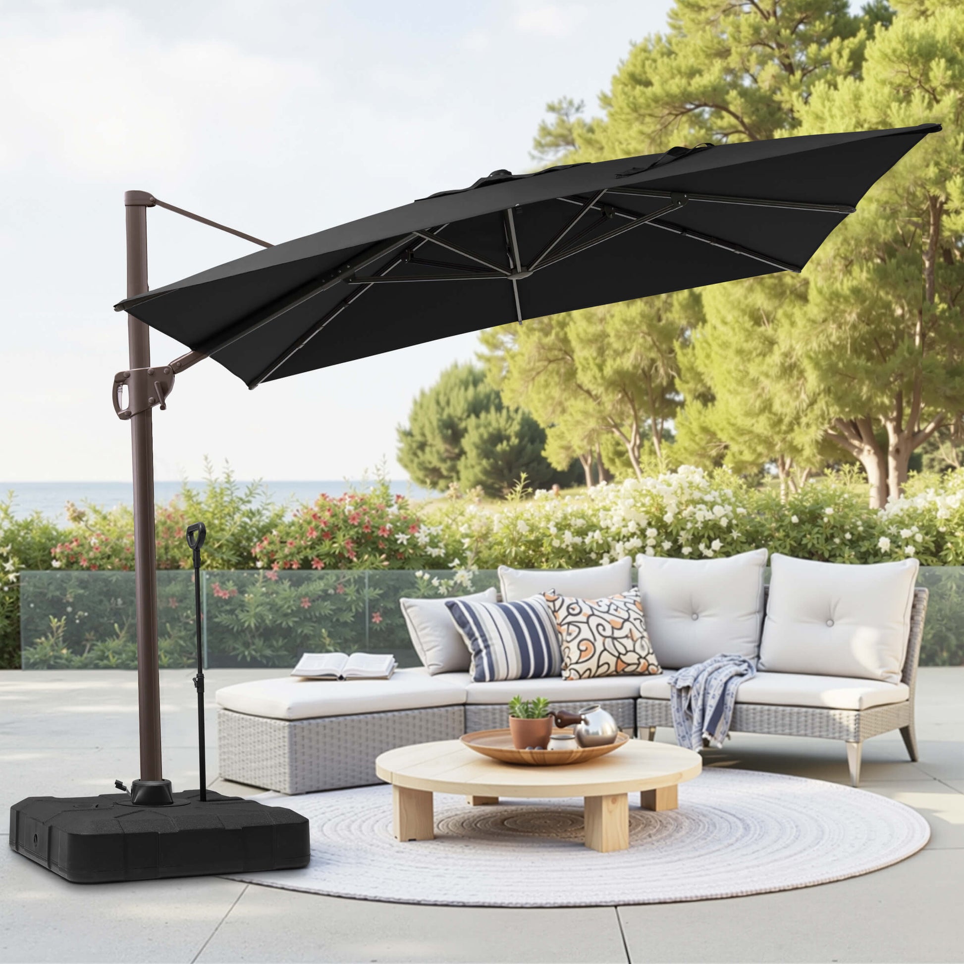 Black rectangular cantilever umbrella with pull-rod base over patio lounge seating.