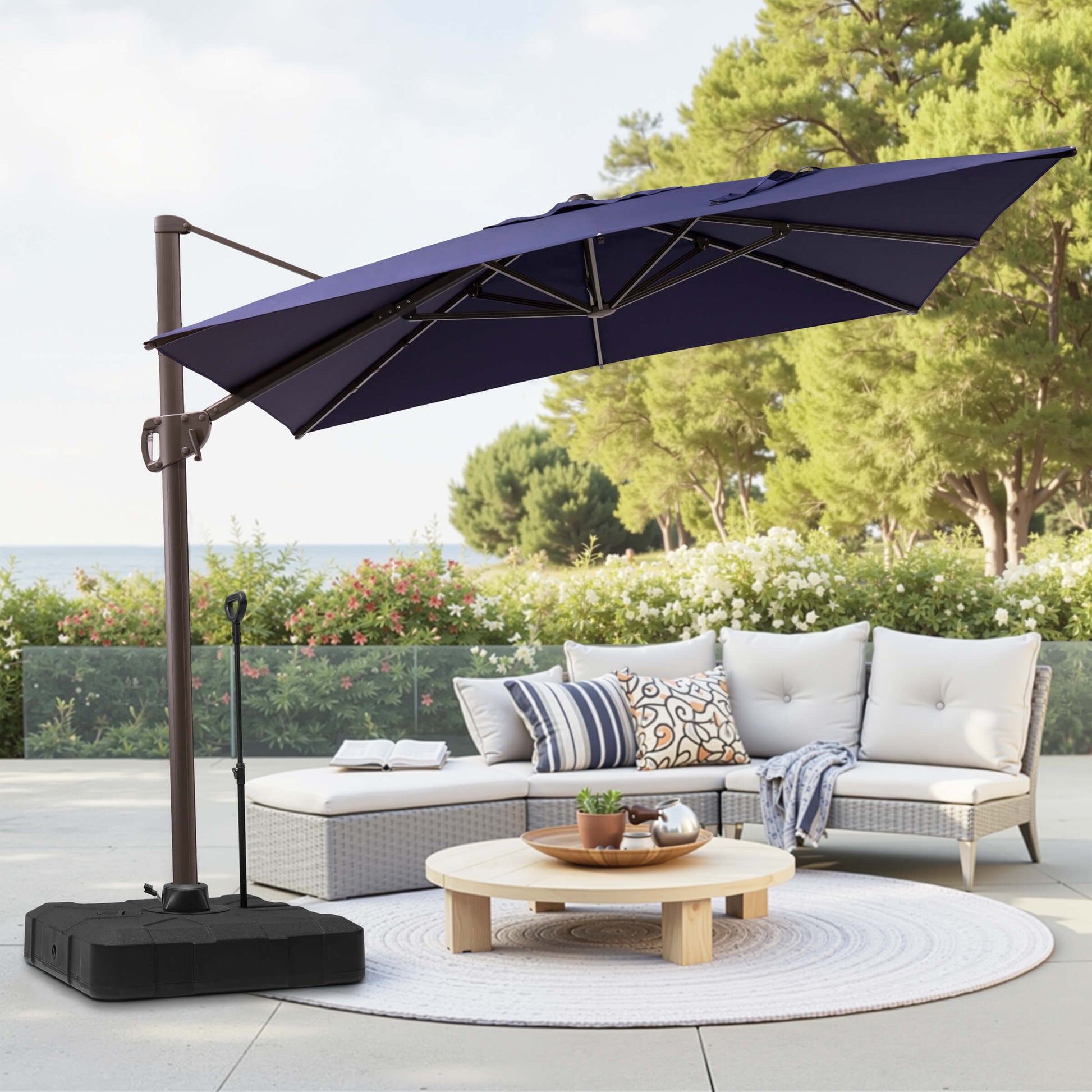 Navy blue rectangular cantilever umbrella with pull-rod base over patio lounge seating.