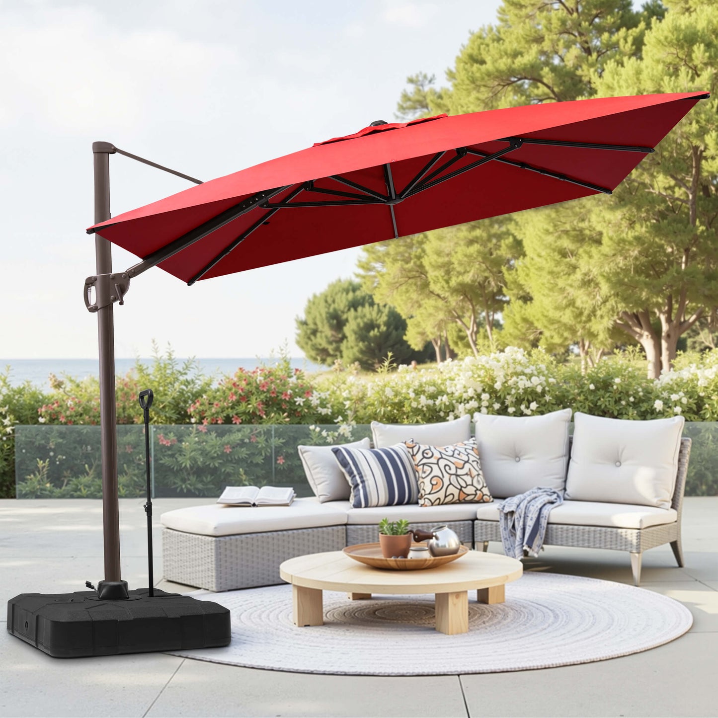 Red rectangular cantilever umbrella with    pull-rod base over patio lounge seating.