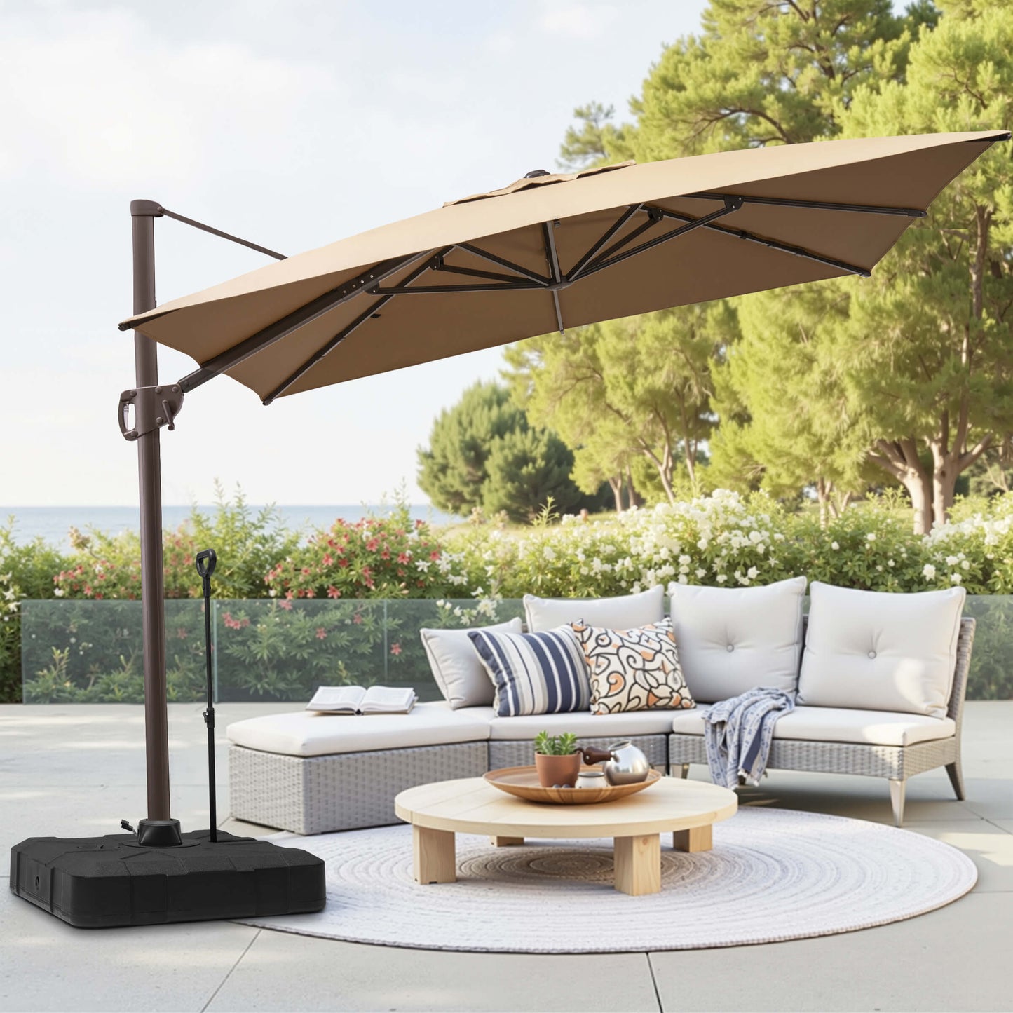 Beige rectangular cantilever umbrella with pull-rod base over patio lounge seating.