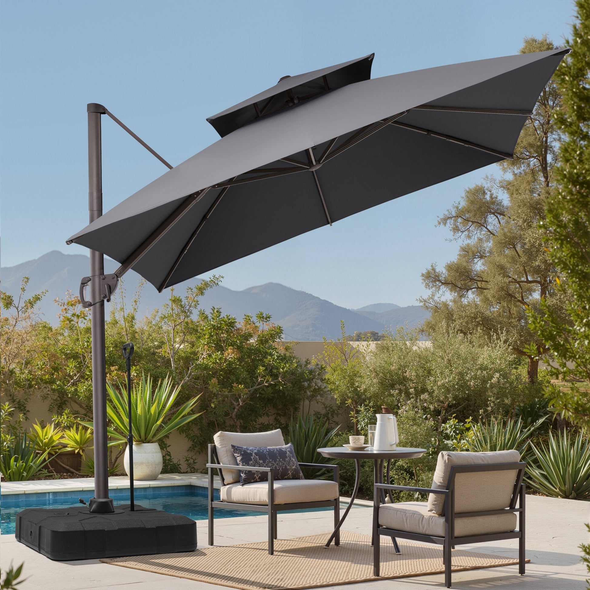 Tilted 10x10 ft square grey cantilever patio umbrella with wheeled base shading a poolside dining set