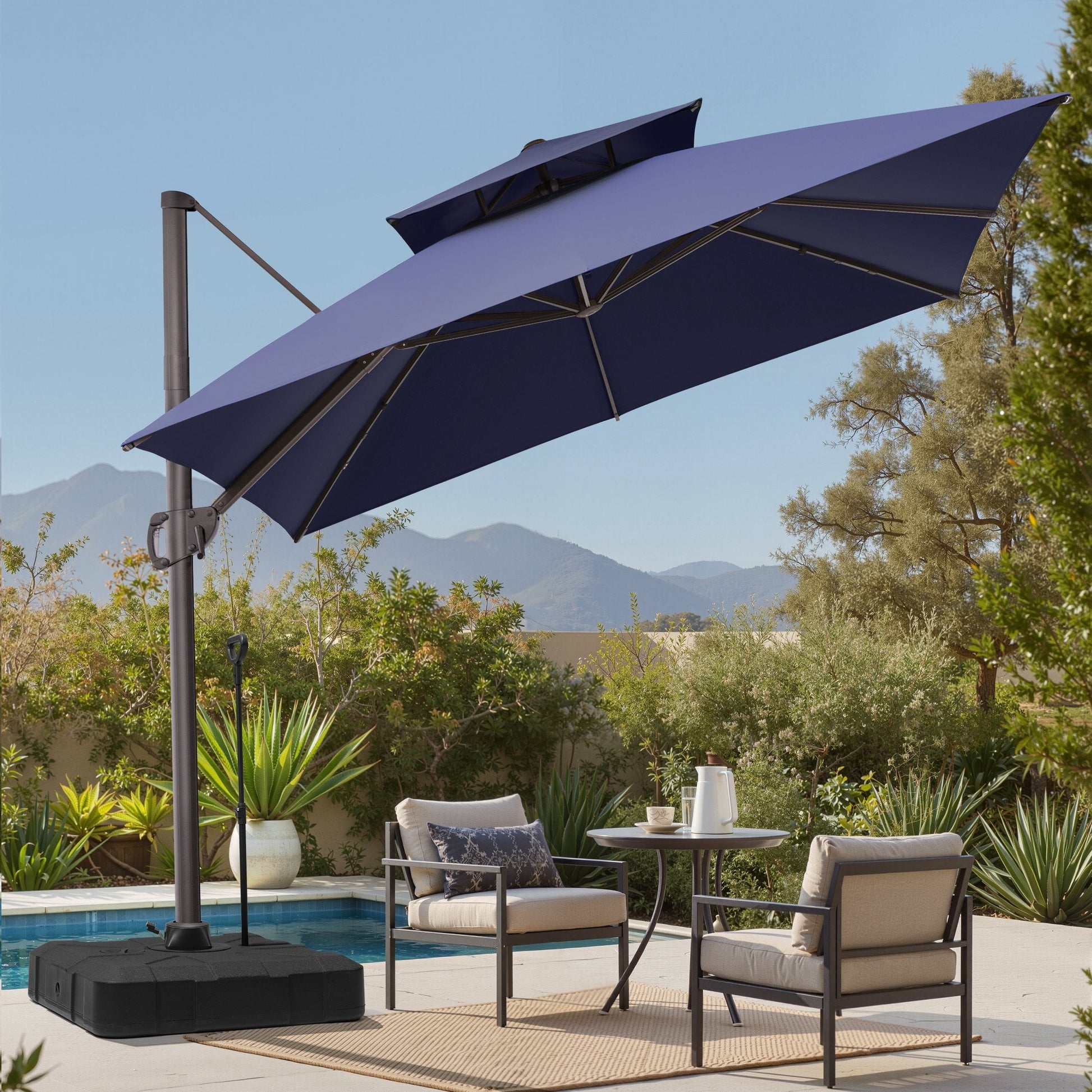 Tilted 10x10 ft square navy blue cantilever patio umbrella with wheeled base shading a poolside seating set