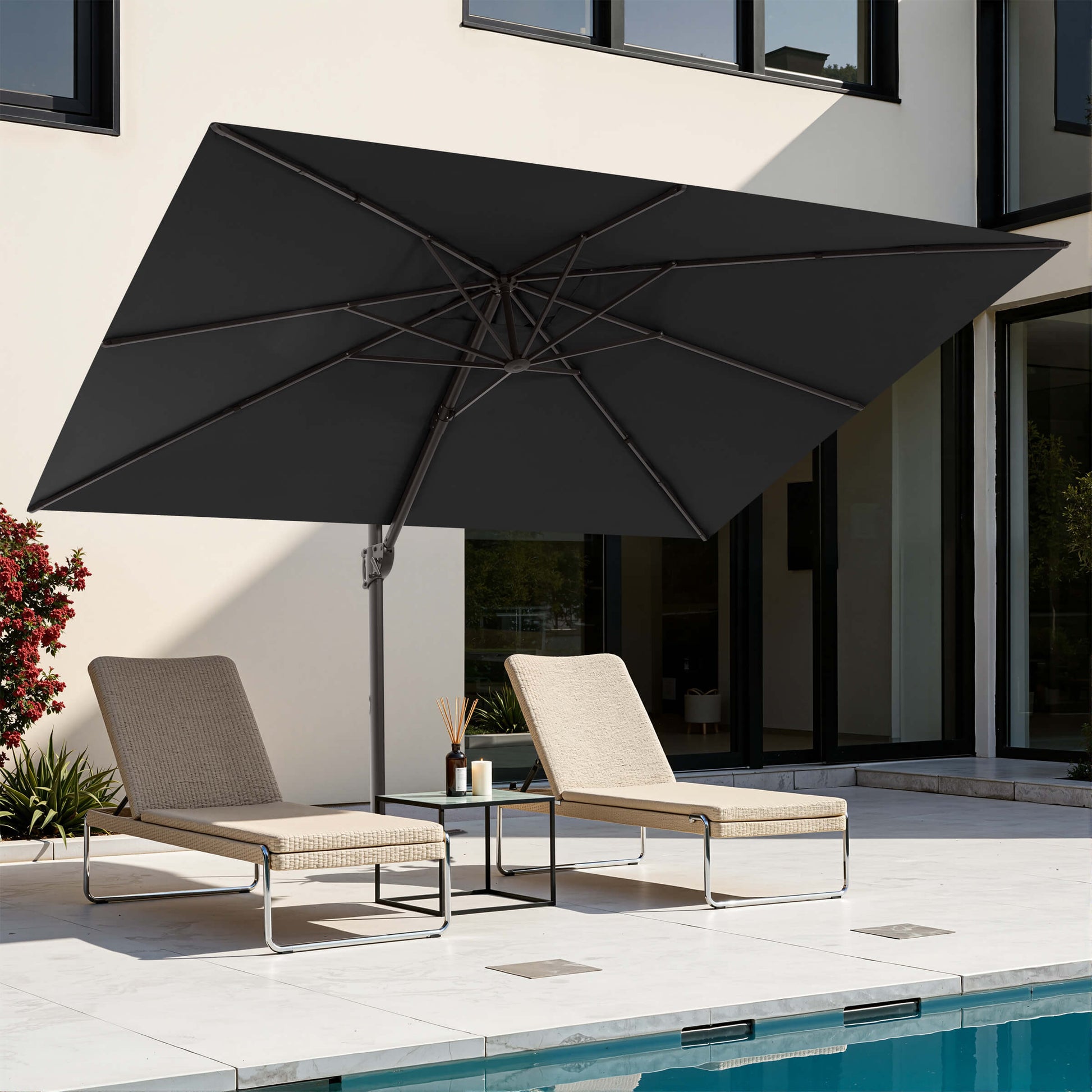 Black rectangular cantilever patio umbrella over poolside lounge chairs.
