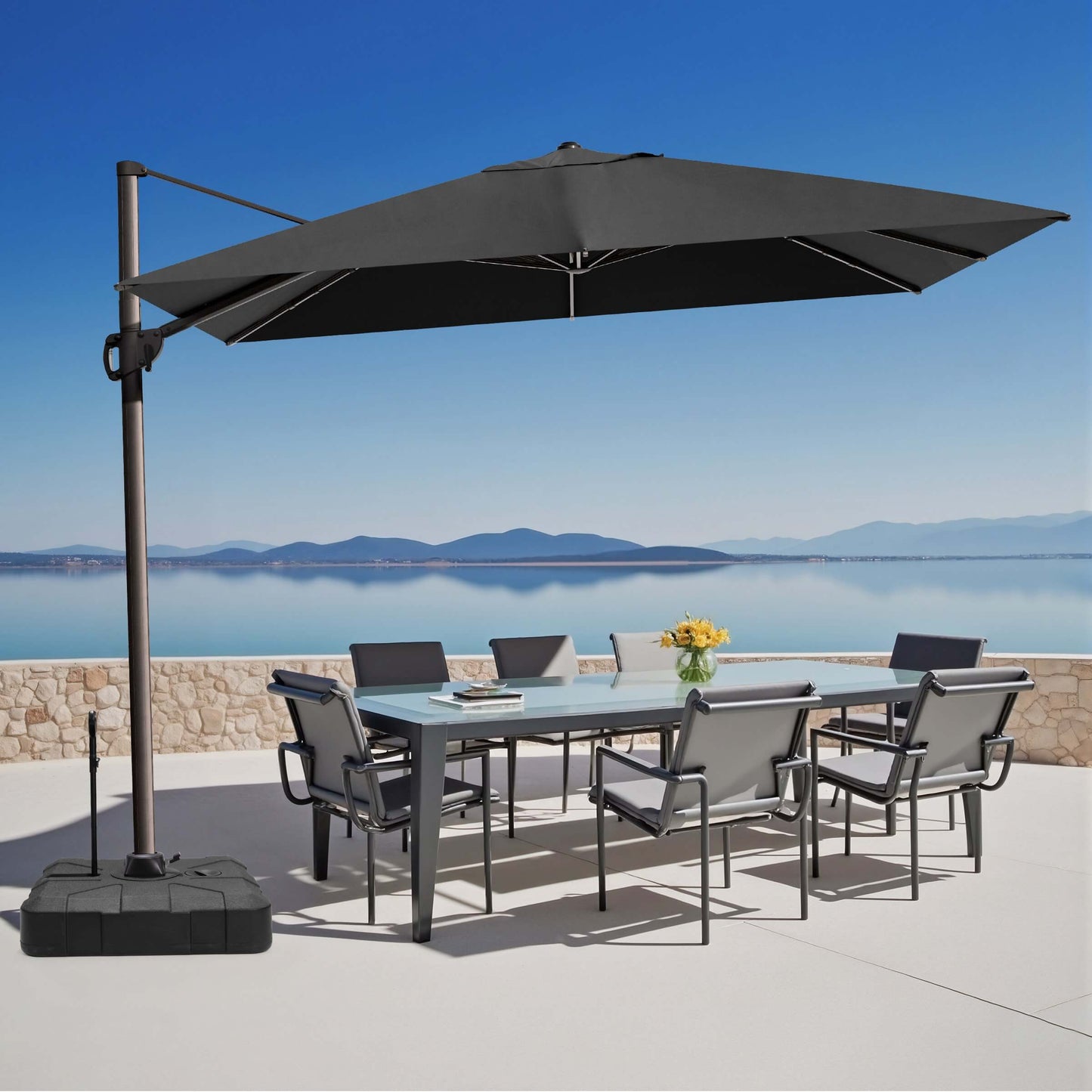 Black rectangular cantilever umbrella with pull-rod base over outdoor dining set.