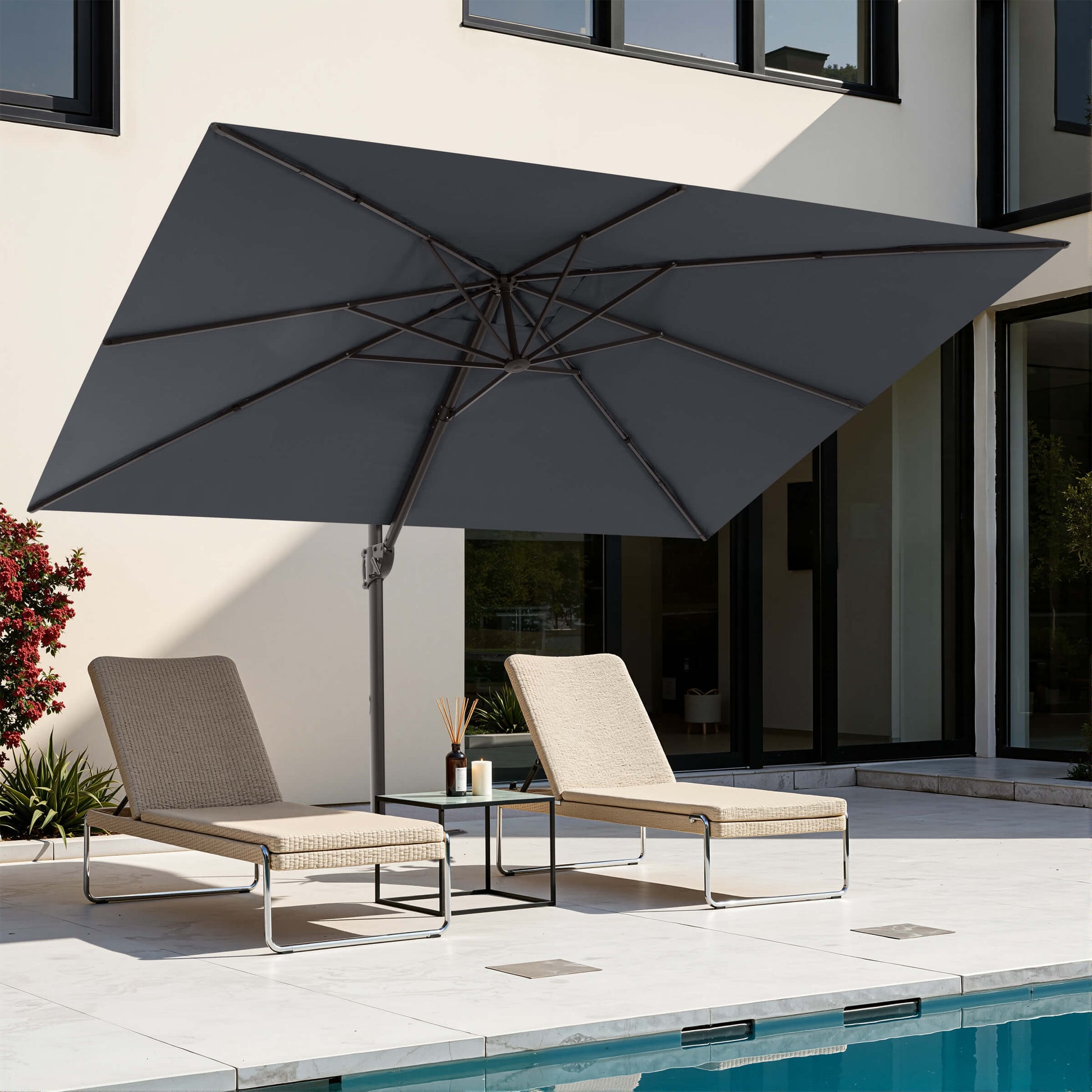 Grey rectangular cantilever patio umbrella over poolside lounge chairs.