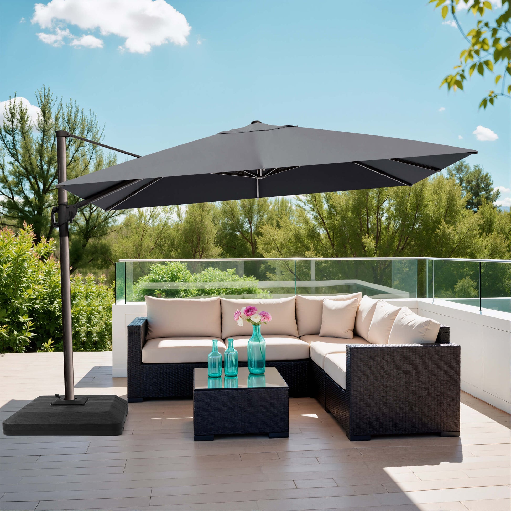 Grey rectangular cantilever umbrella with weighted base over patio sofa.