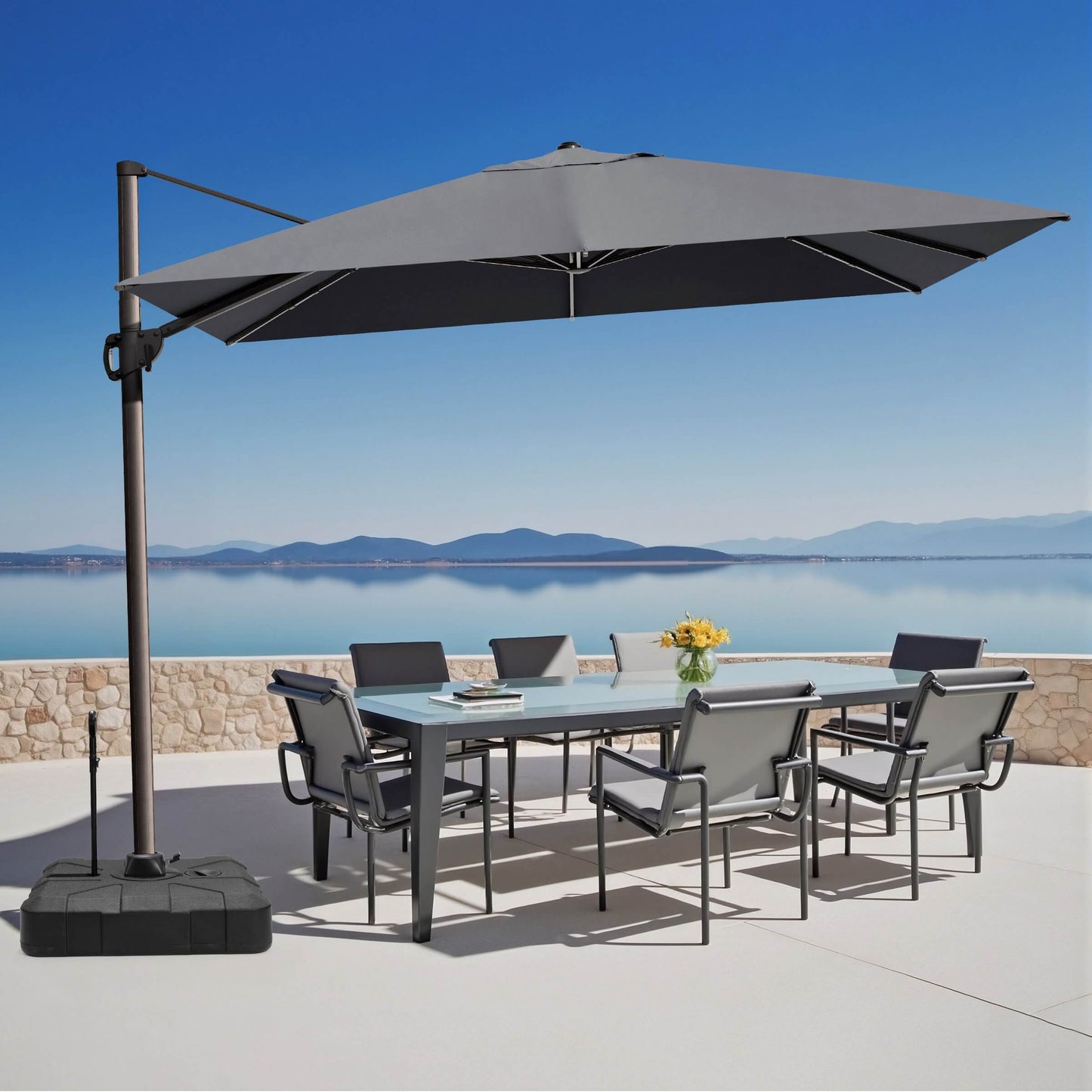 Grey rectangular cantilever umbrella with pull-rod base over outdoor dining set.