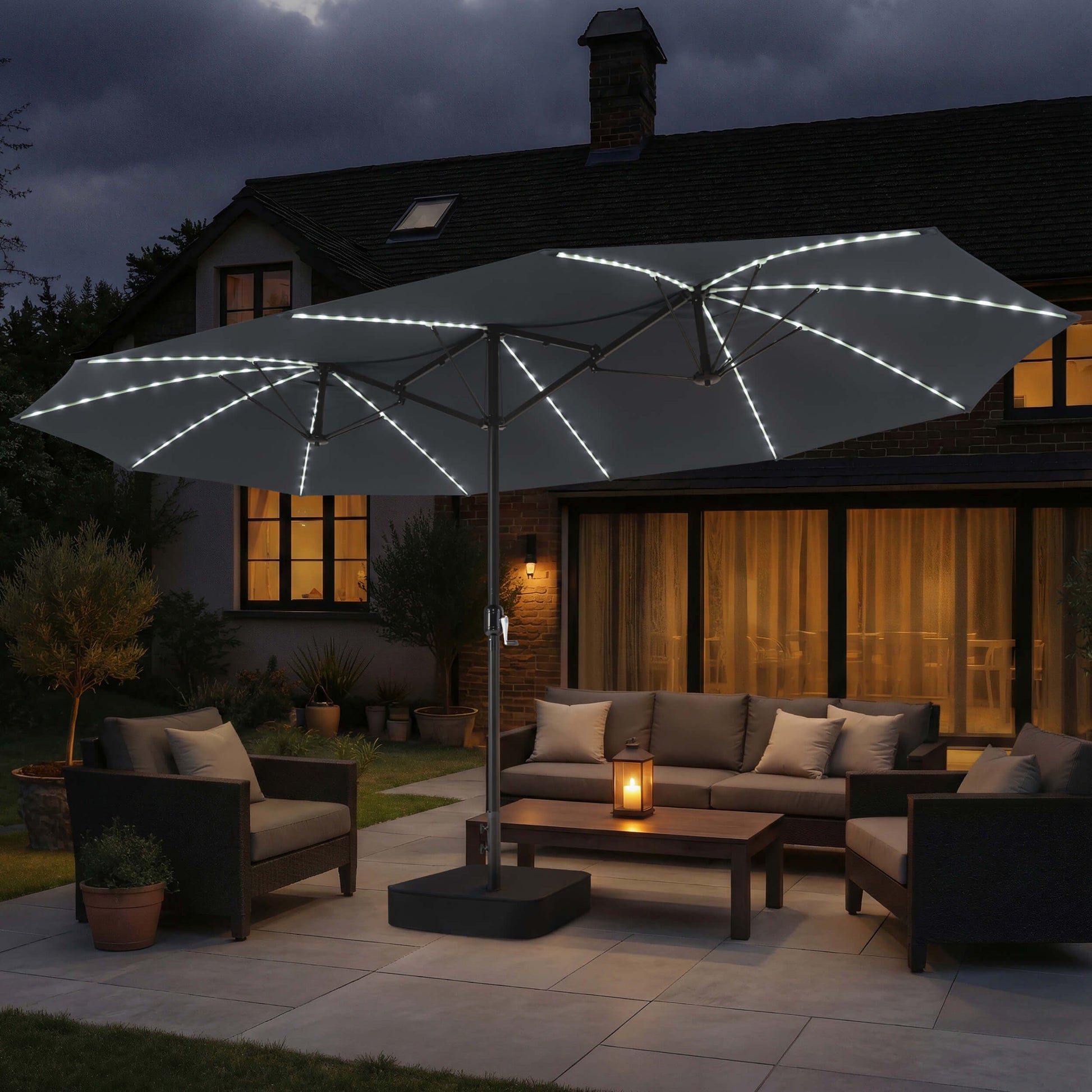 15x9 ft dark grey double-sided market umbrella with solar LED lights shading a patio sofa set at night.