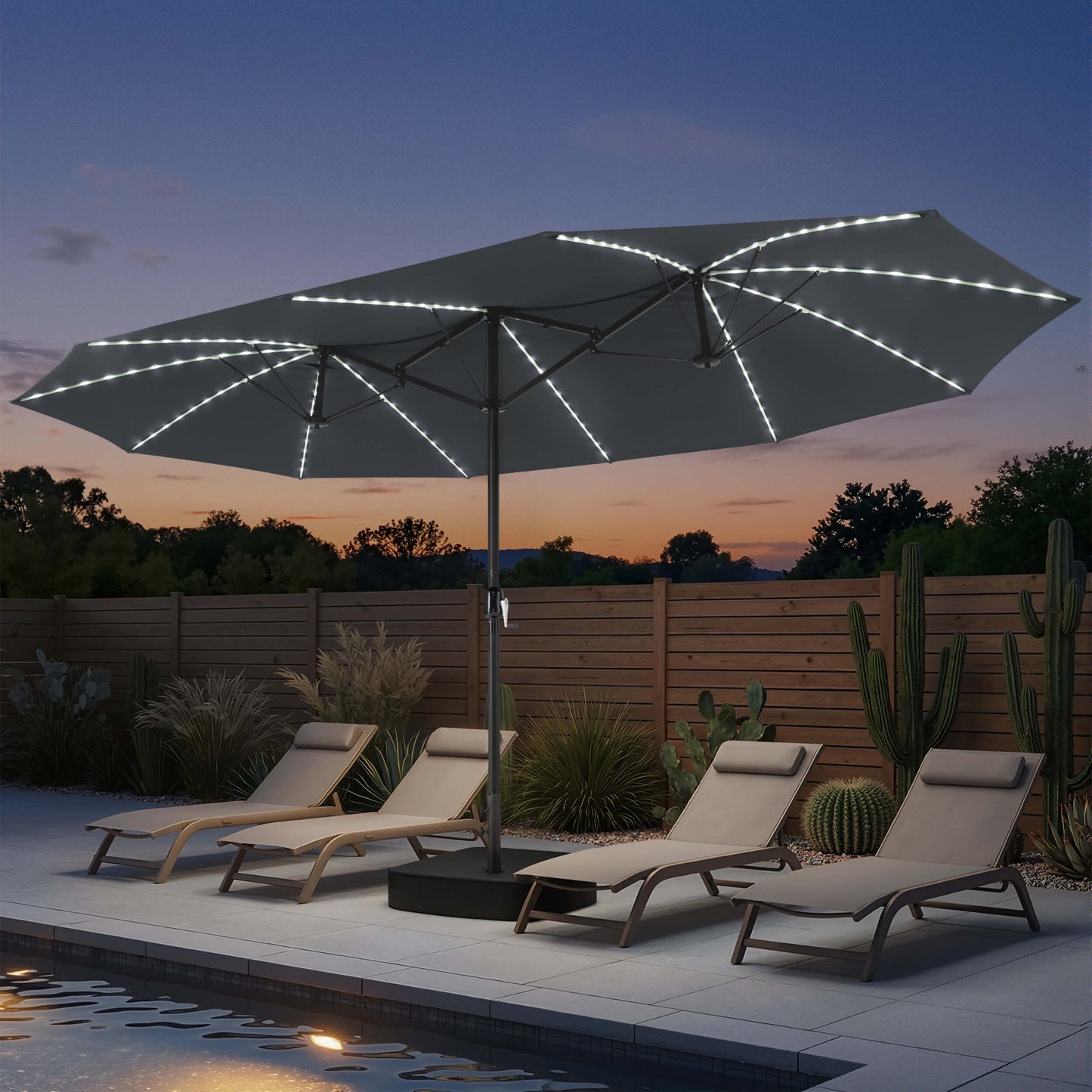 15x9 ft dark grey double-sided market umbrella with solar LED lights shading poolside chaise lounges at night.