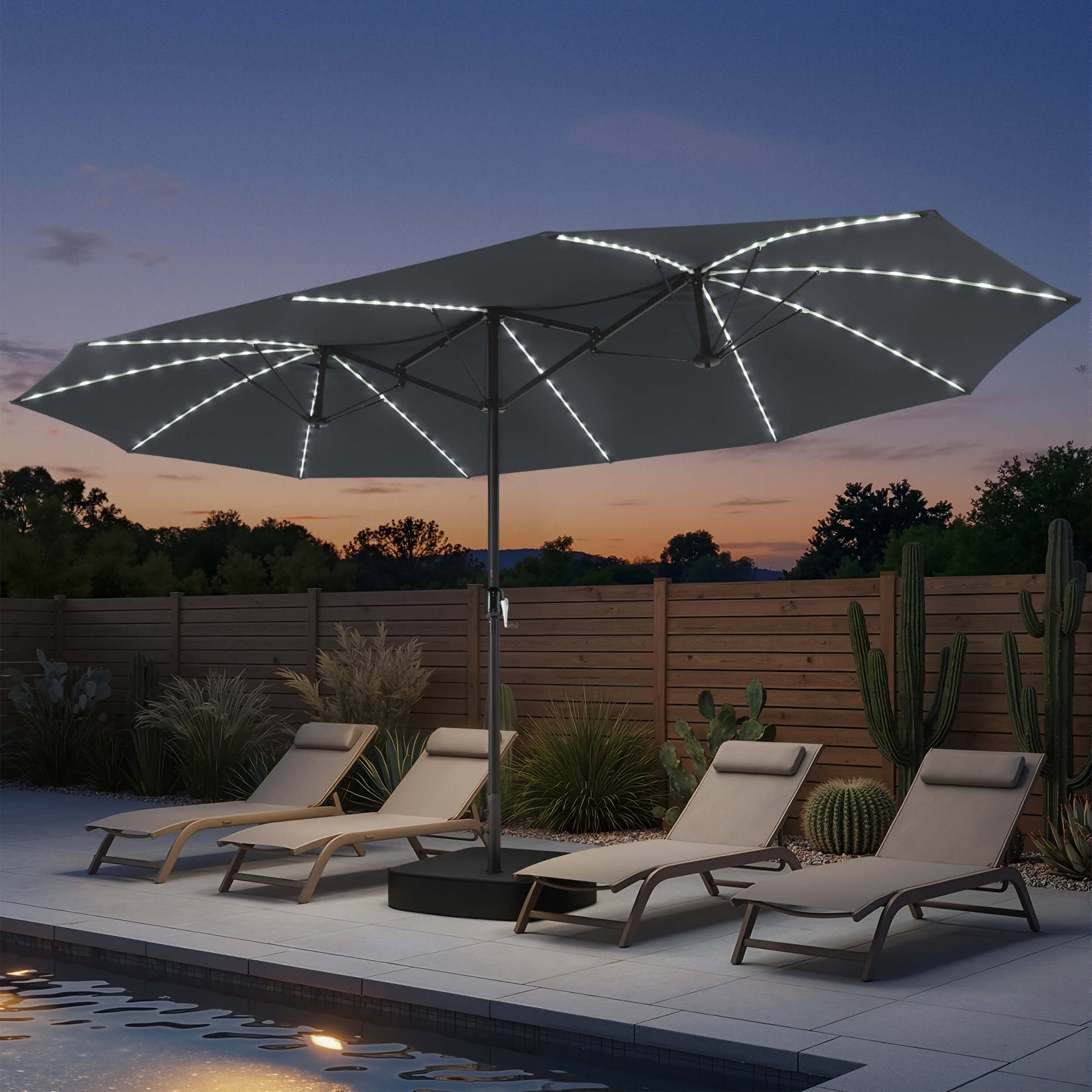 15x9 ft dark grey double-sided market umbrella with solar LED lights shading poolside chaise lounges at night.
