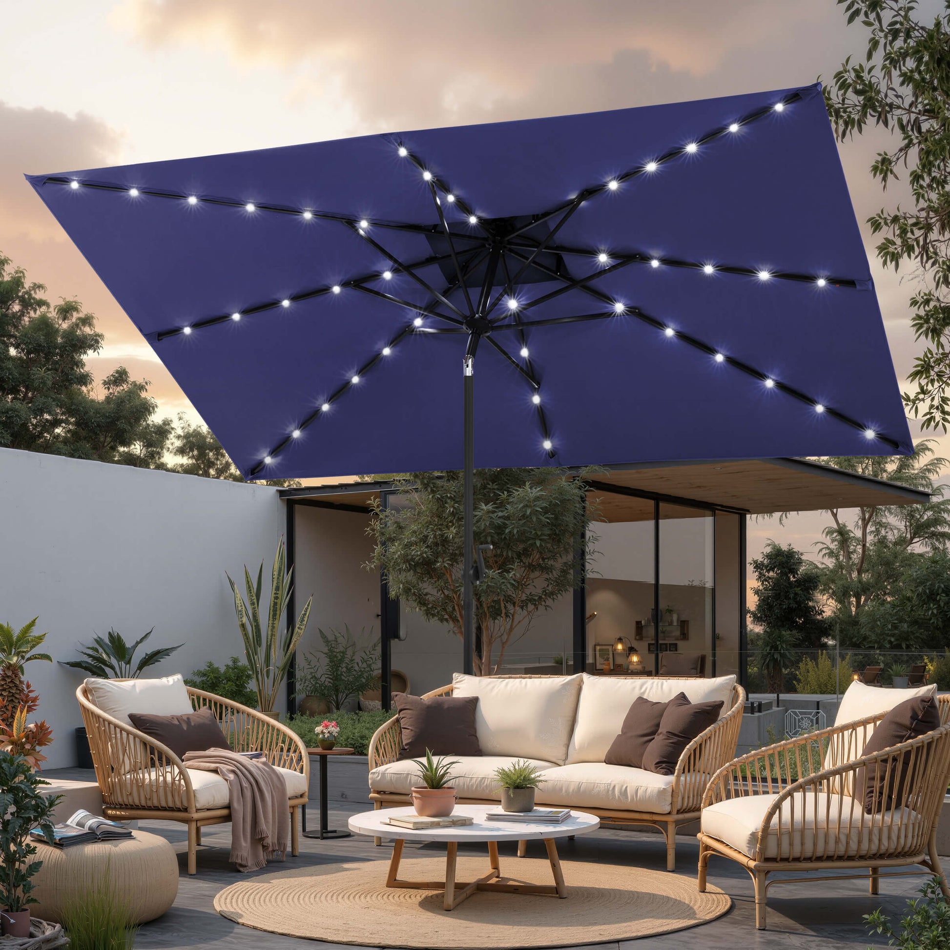 10x7 ft navy market umbrella with solar LED lights shading a backyard patio sofa set at night.
