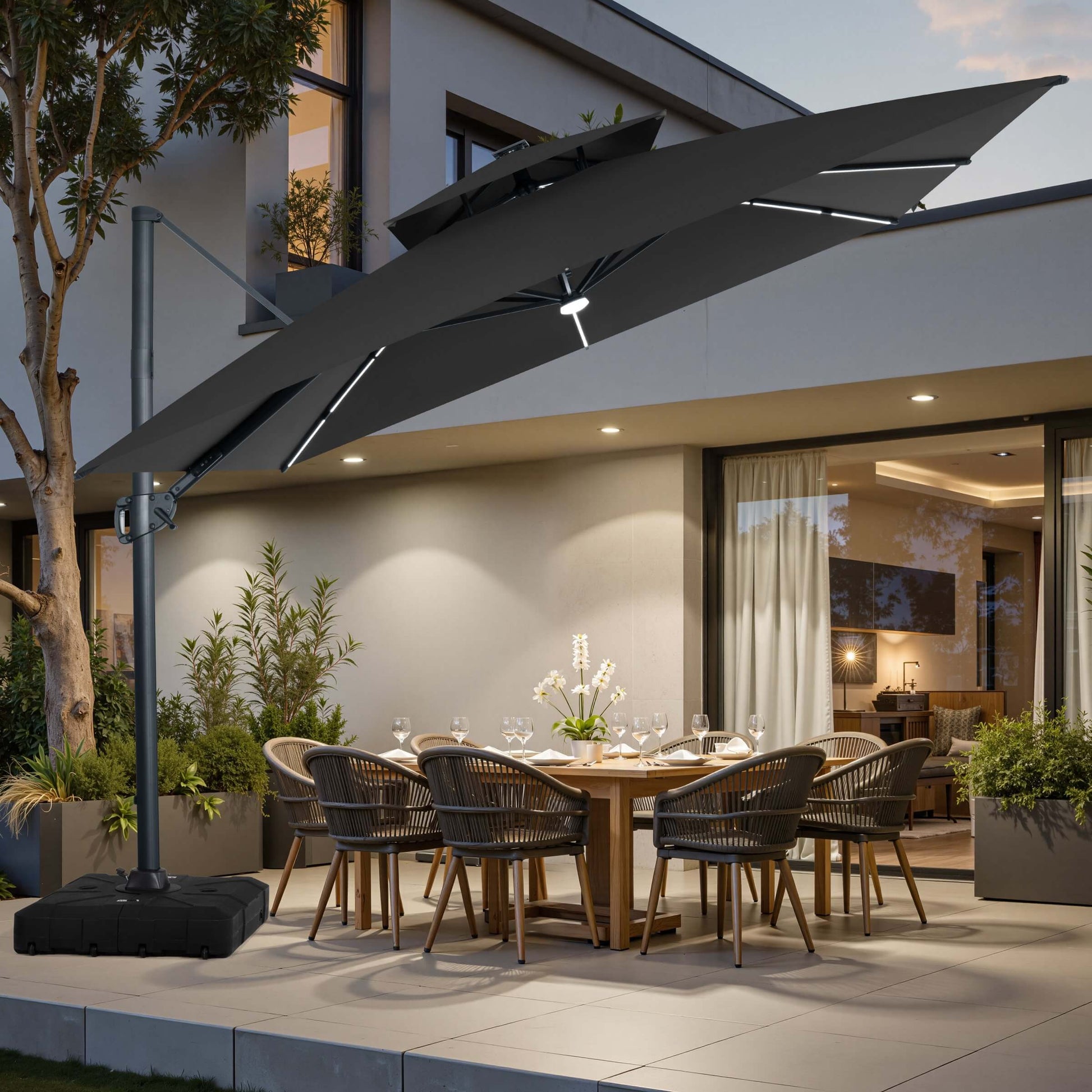 Black LED cantilever umbrella on a wheeled base over a patio dining set.