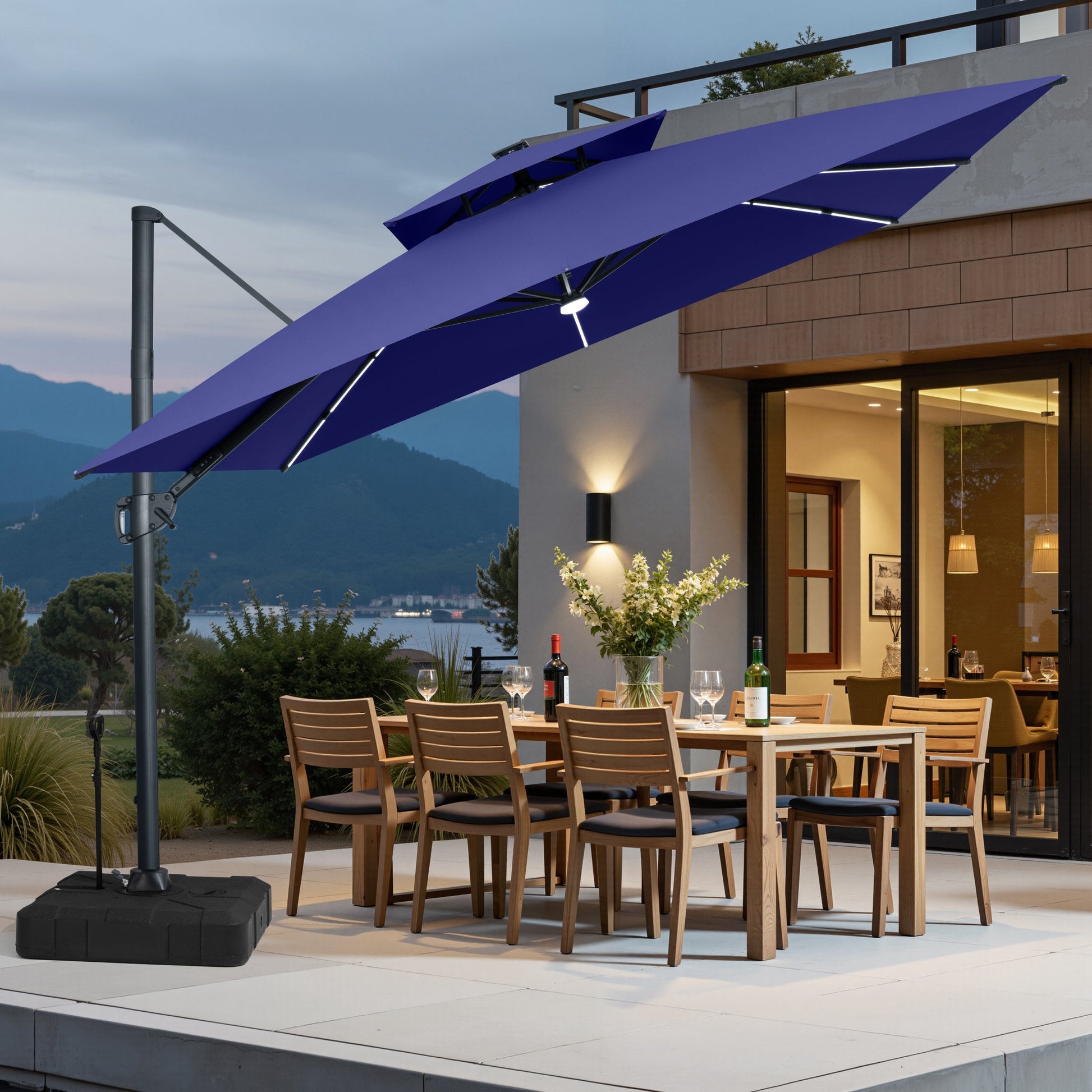 Navy blue LED cantilever umbrella on pull-rod base over a patio dining set.