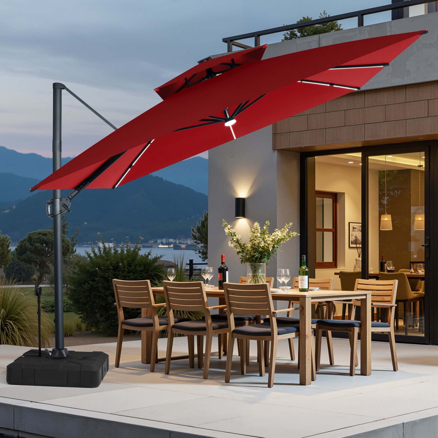 Red LED cantilever umbrella on pull-rod base over a patio dining set.