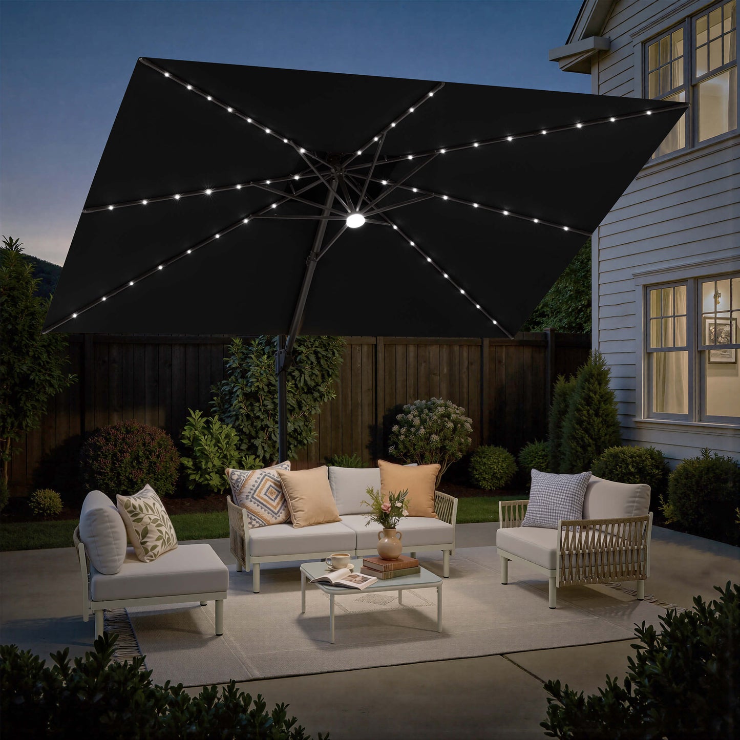 Lighted Crestlive 12x9 ft black cantilever umbrella with cross base shading a patio sofa set at night