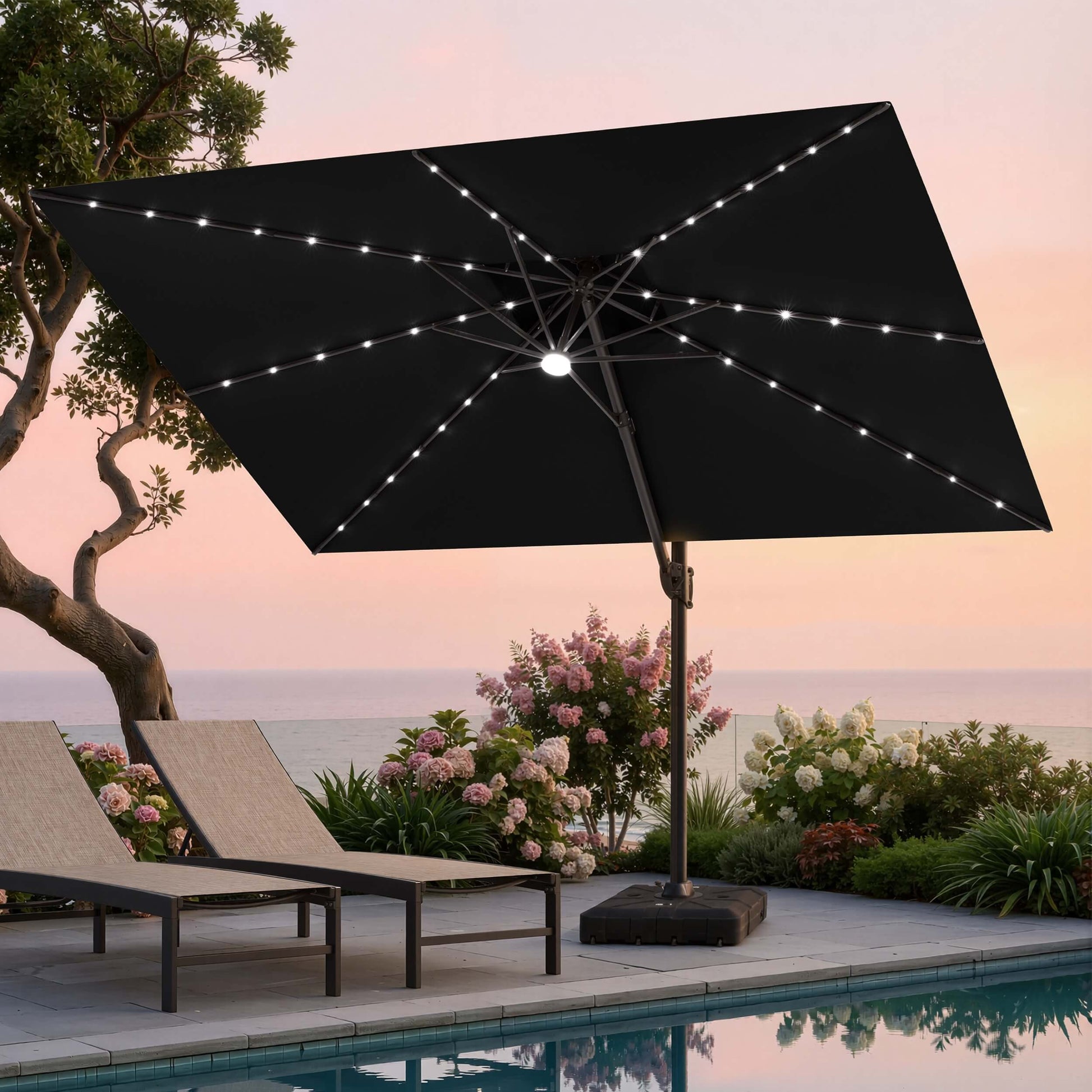 Tilted 12x9 ft black lighted cantilever umbrella with heavy-duty base shading poolside lounge chairs at sunset