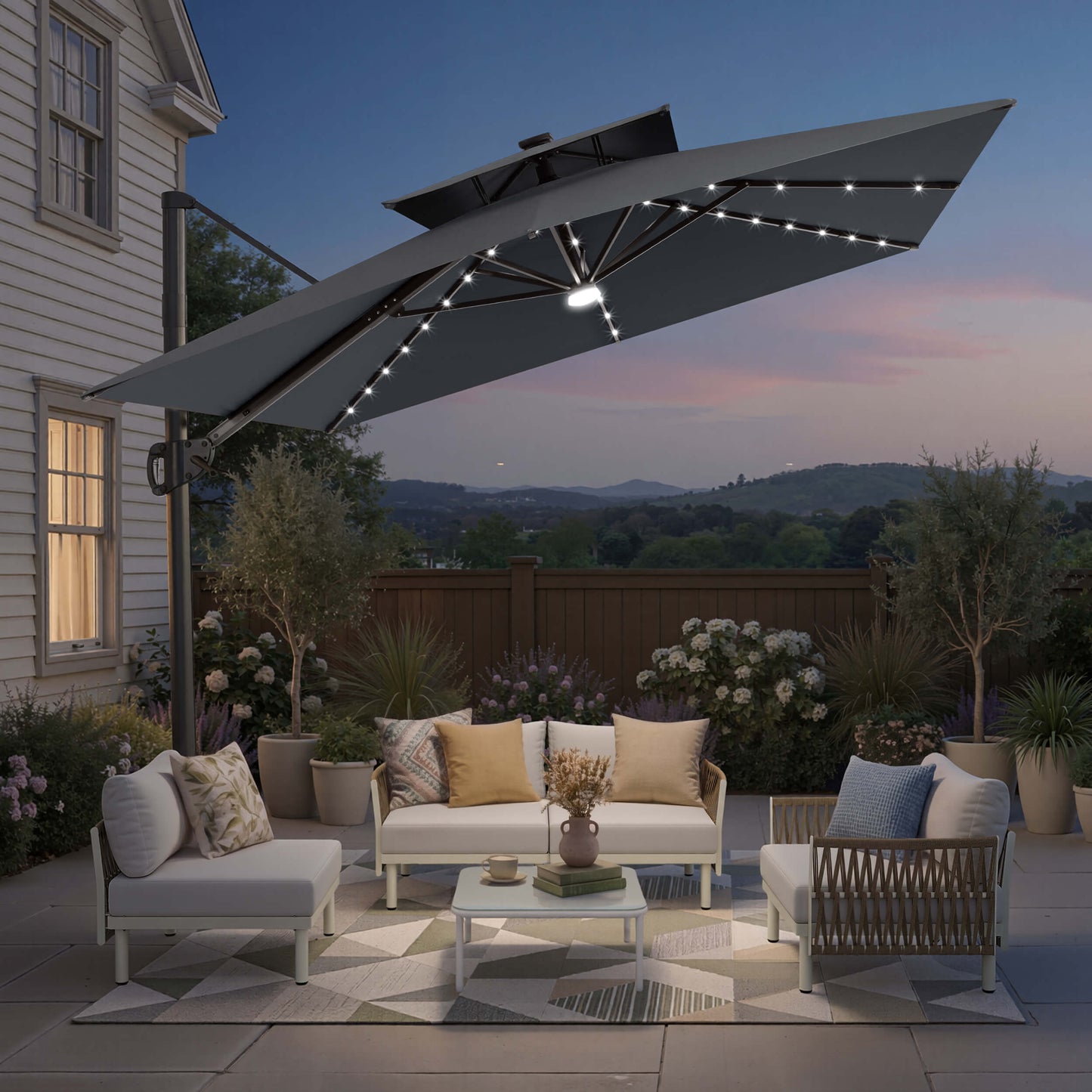 Tilted 12x9 ft grey lighted cantilever umbrella with cross base shading a patio sofa set at twilight
