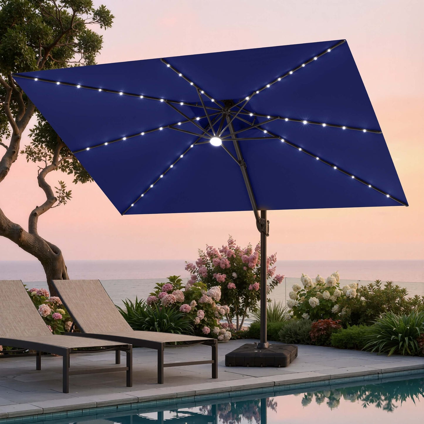 Tilted 12x9 ft navy blue lighted cantilever umbrella with heavy-duty base shading poolside lounge chairs at sunset