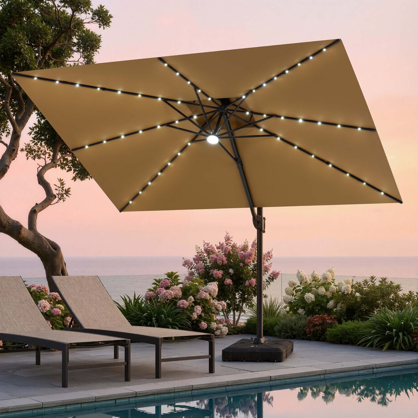 Tilted 12x9 ft beige lighted cantilever umbrella with heavy-duty base shading poolside lounge chairs at sunset