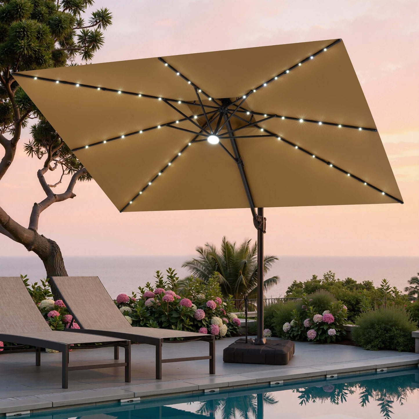 Tilted 12x9 ft beige lighted cantilever umbrella with wheeled base shading poolside lounge chairs at sunset
