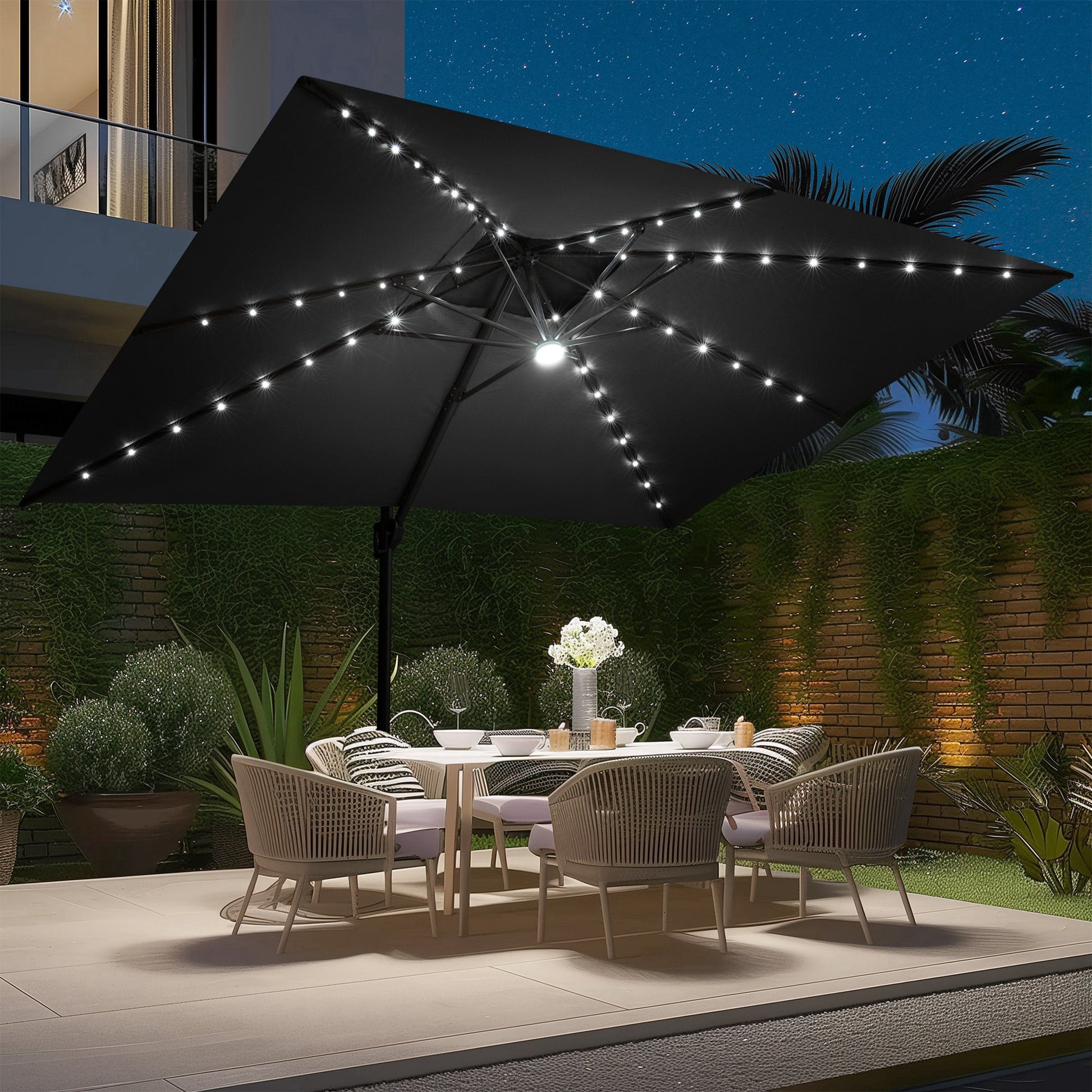 Crestlive black cantilever umbrella with LED lights illuminating a backyard patio dining set at night