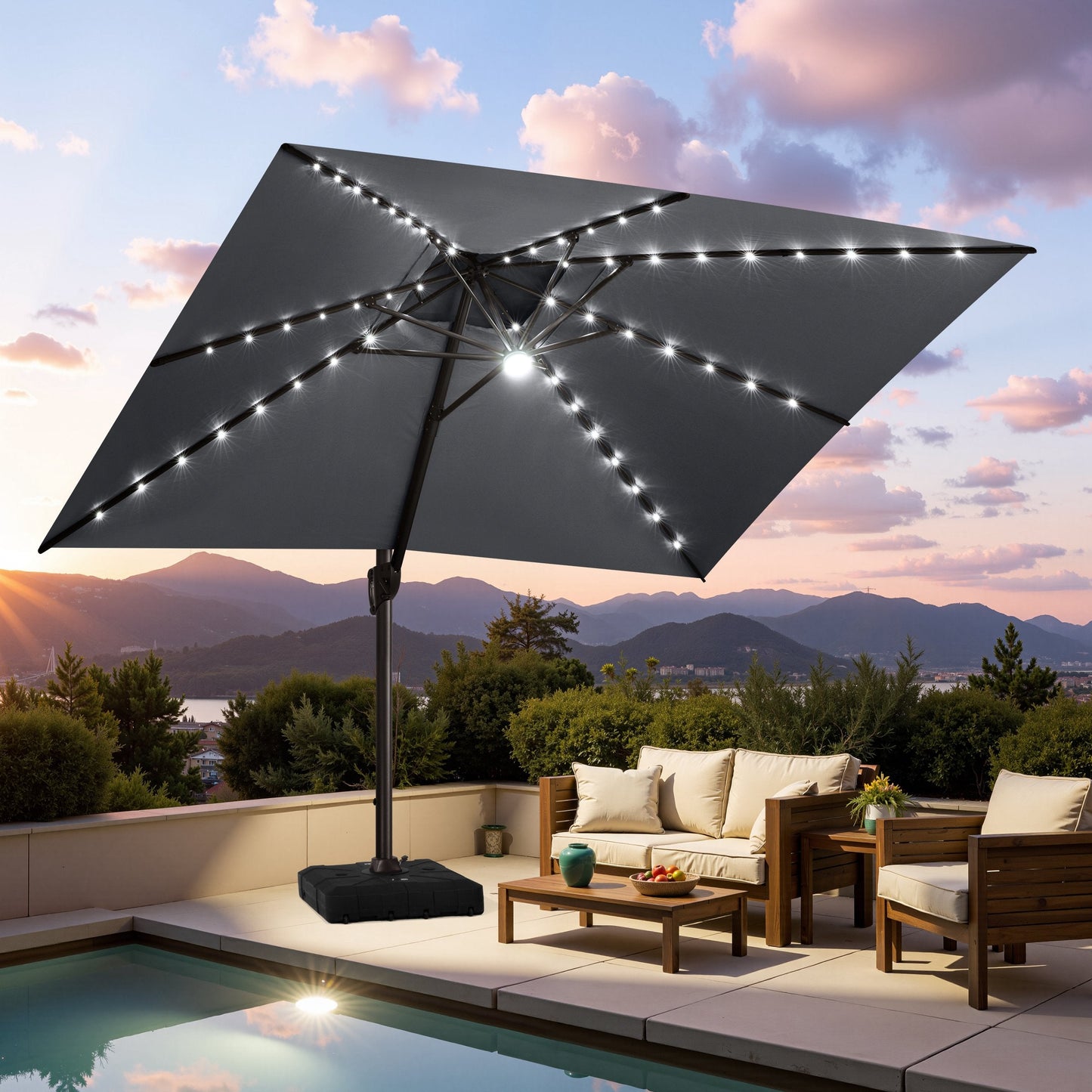 Crestlive dark grey cantilever umbrella with LED lights illuminating a poolside patio lounge set at sunset