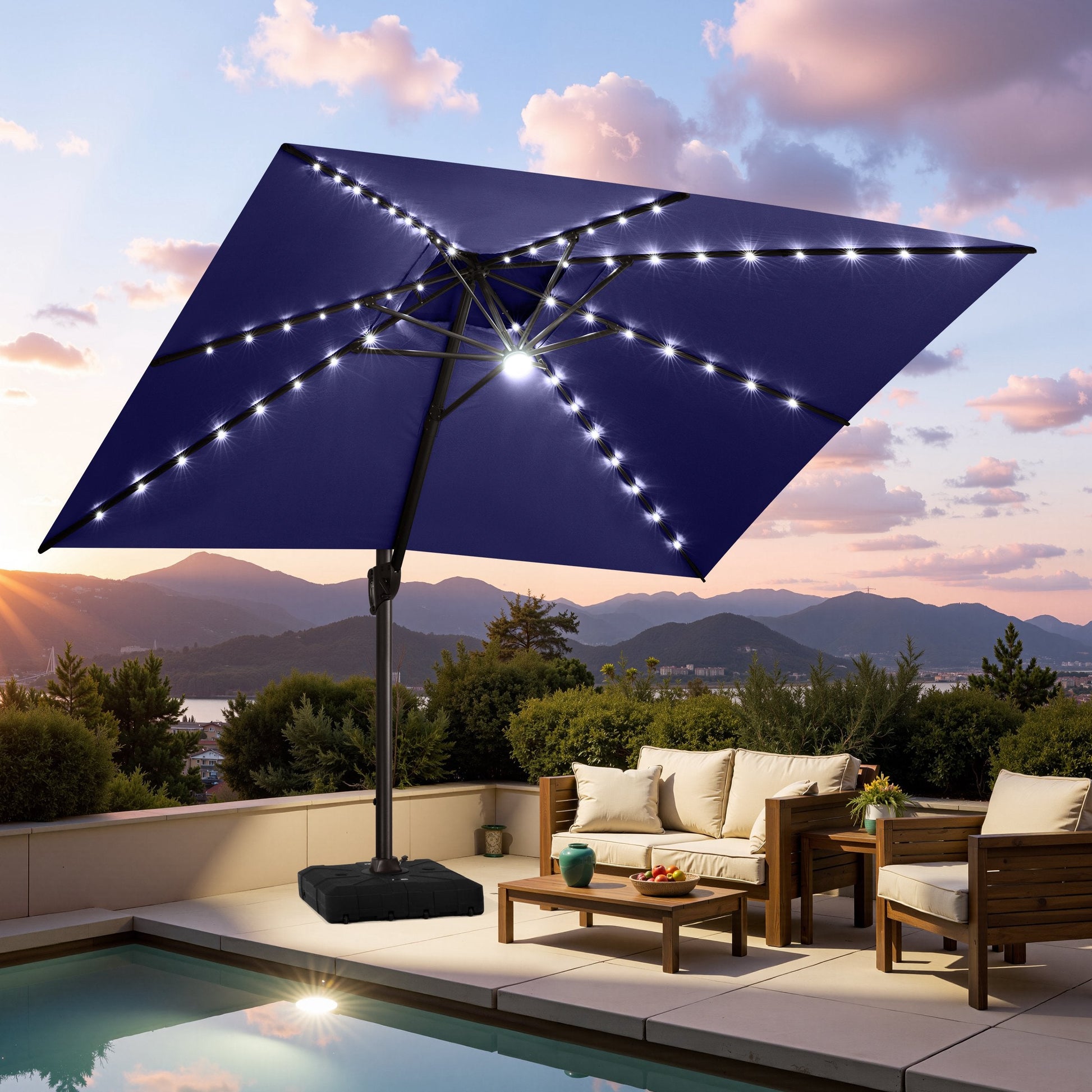 Crestlive navy blue cantilever umbrella with LED lights illuminating a poolside patio lounge set at sunset