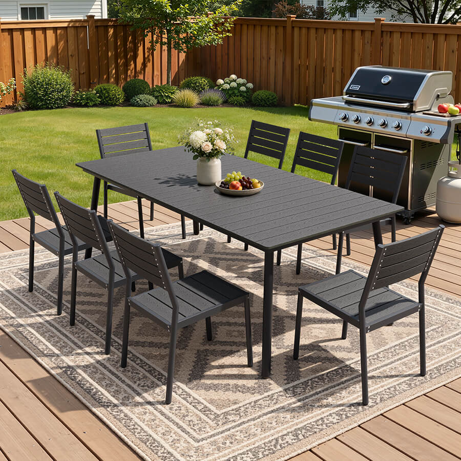 Black 9-piece outdoor dining set with large polywood slatted table and 8 chairs on a backyard patio deck.