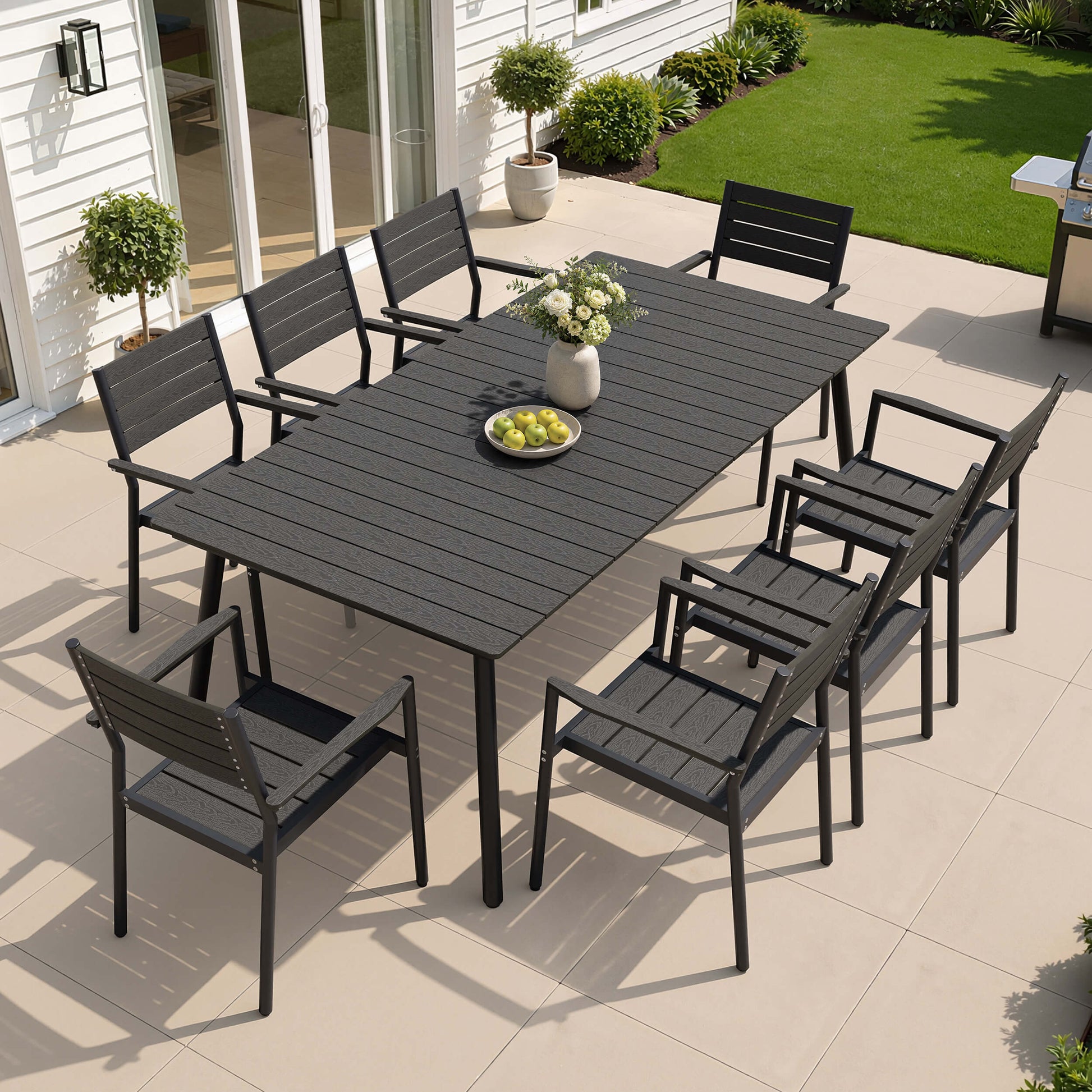 9-piece outdoor patio dining set with black polywood table and 8 chairs set on sunny backyard deck.