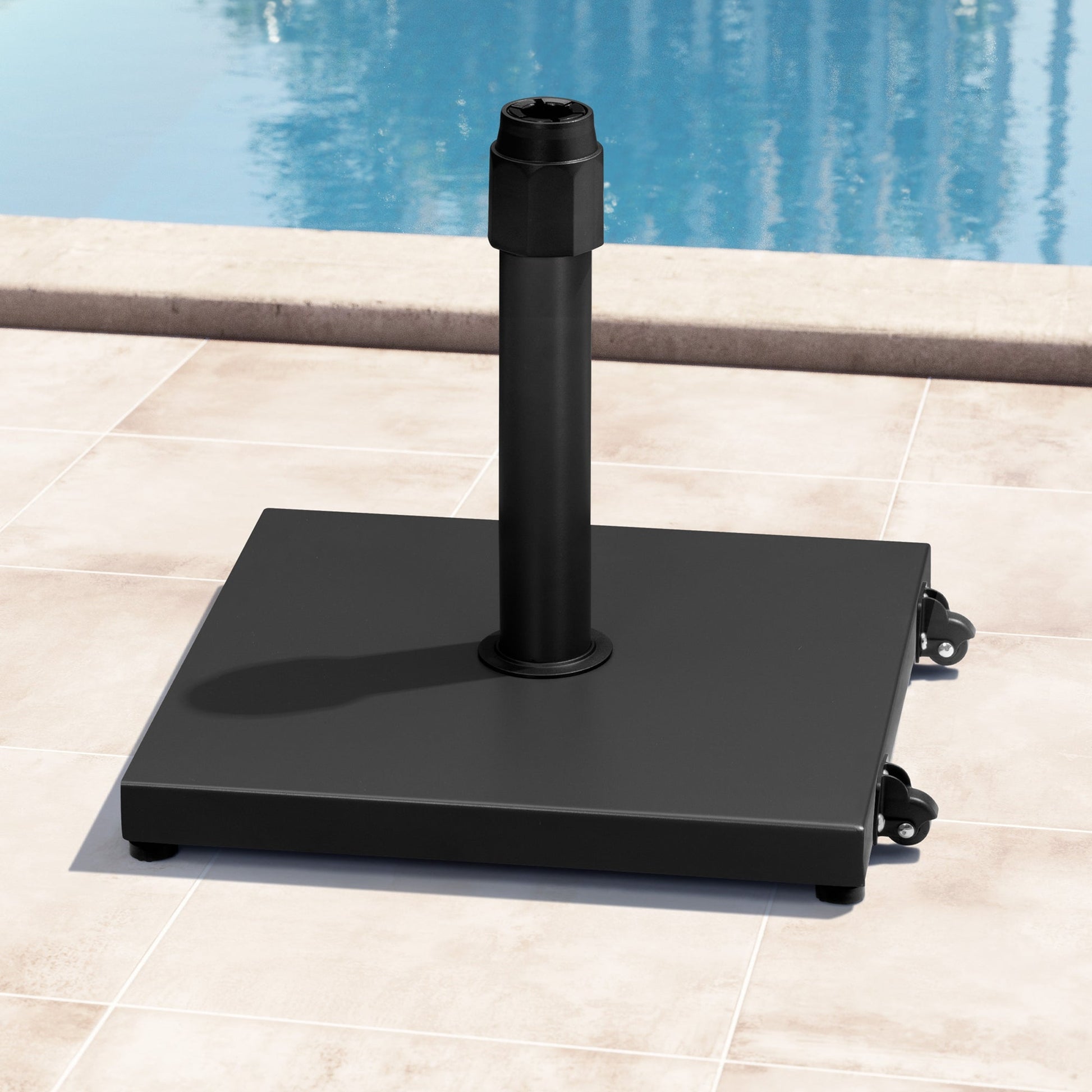 45 lbs square black steel umbrella base with wheels on a poolside patio.