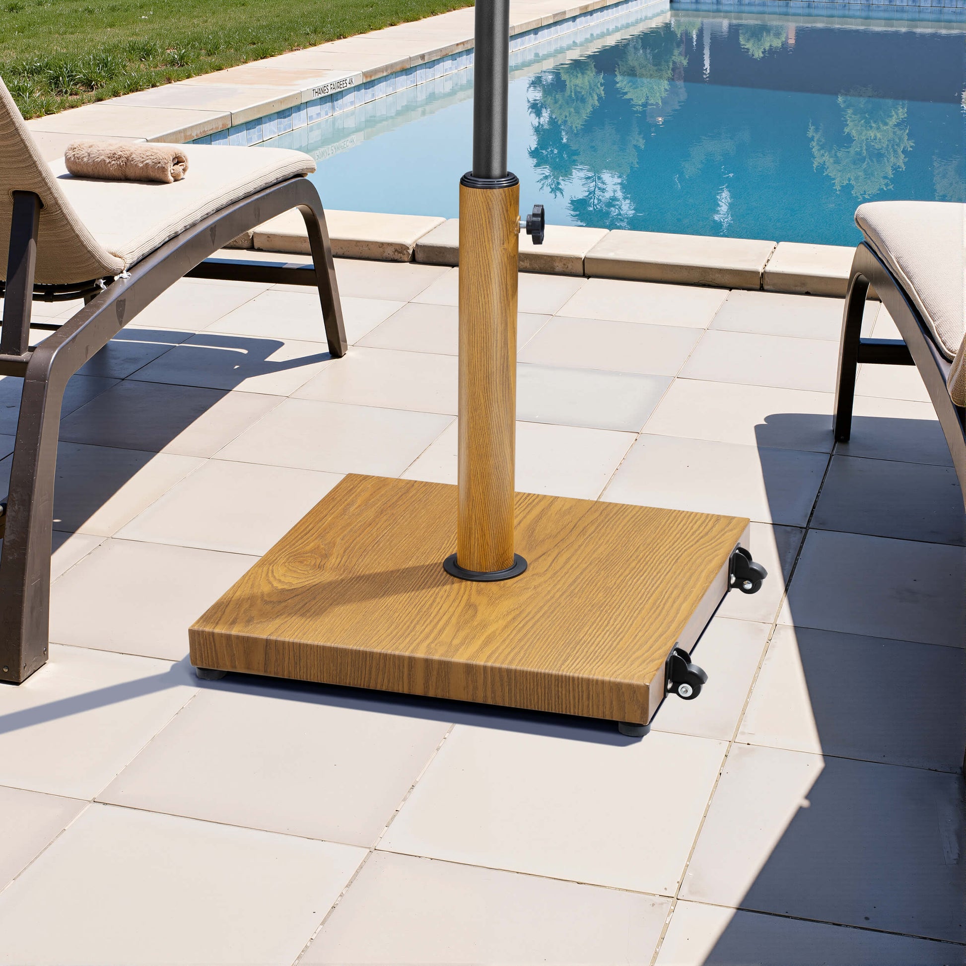 Wood grain square weighted market umbrella base with wheels on poolside patio.