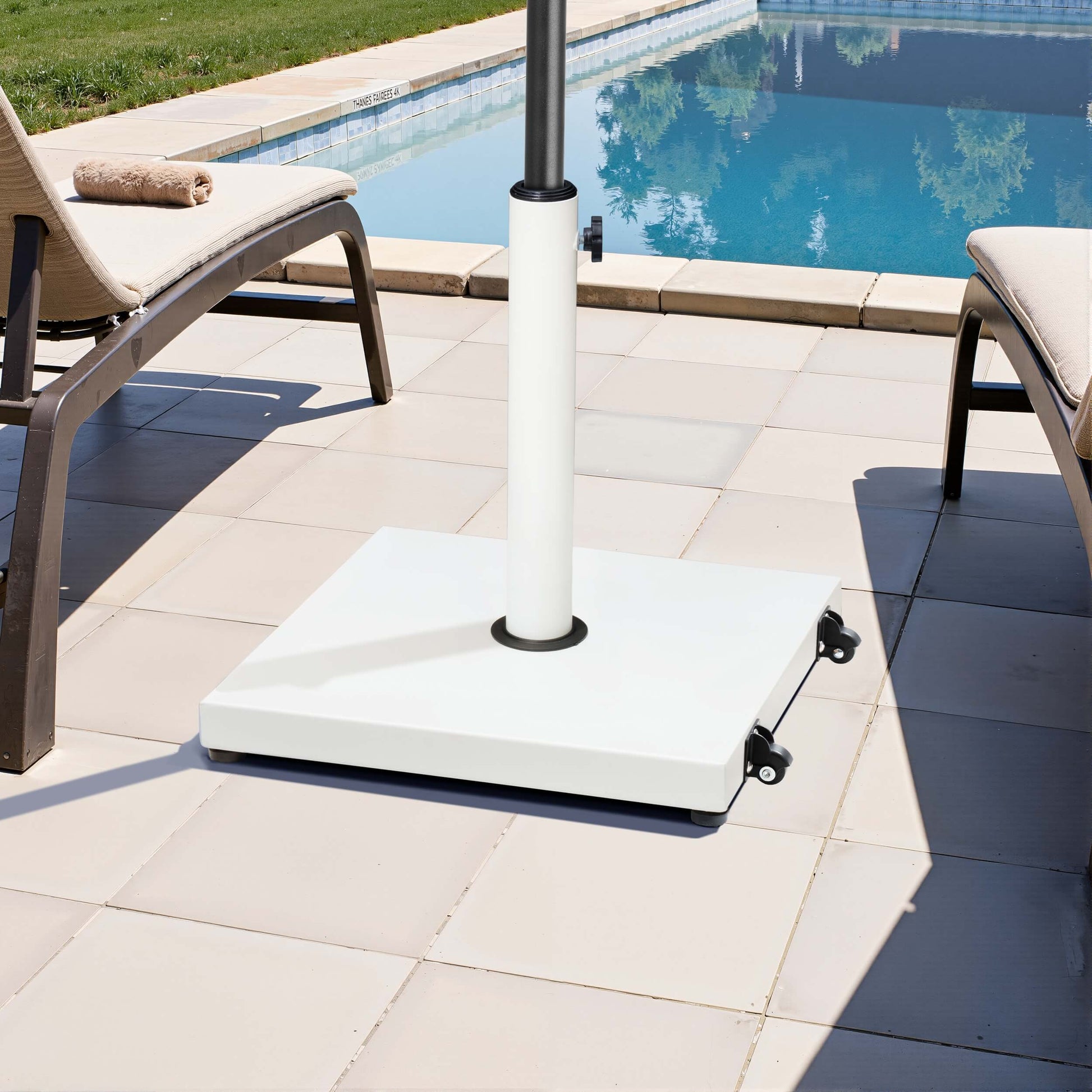 White square weighted market umbrella base with wheels on poolside patio.
