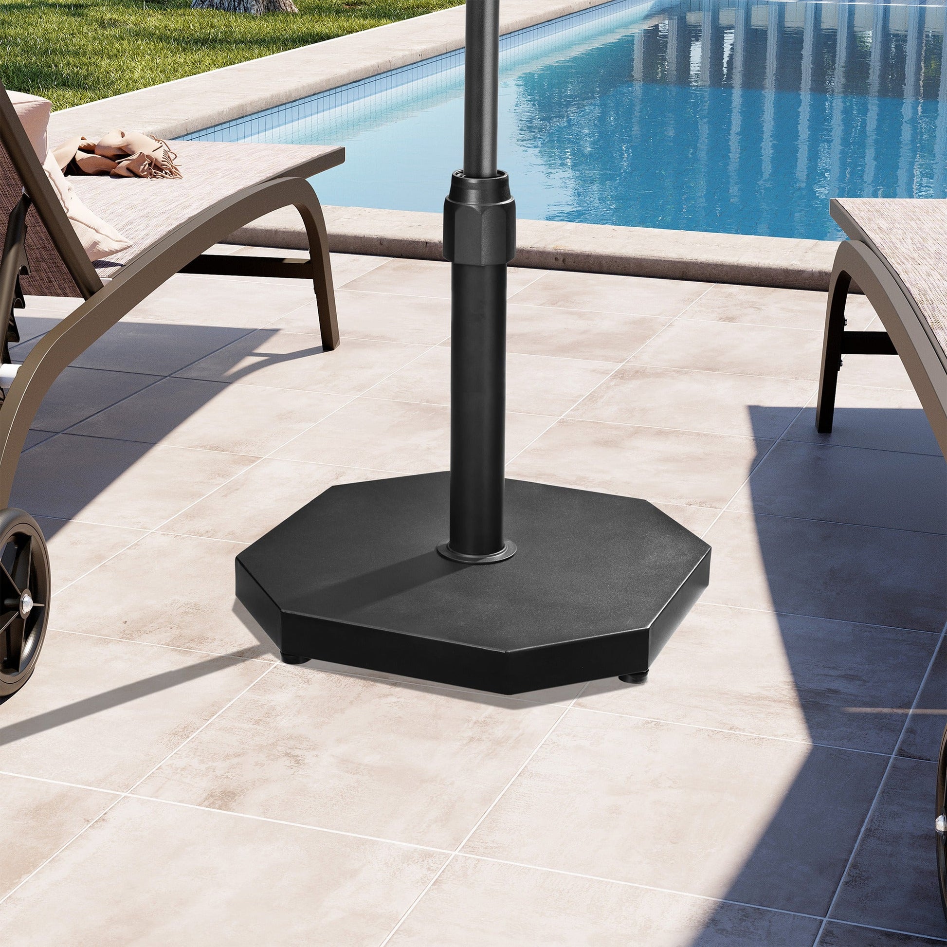 Black 40 lbs octagonal cement market umbrella base between lounge chairs on a sunny poolside patio.