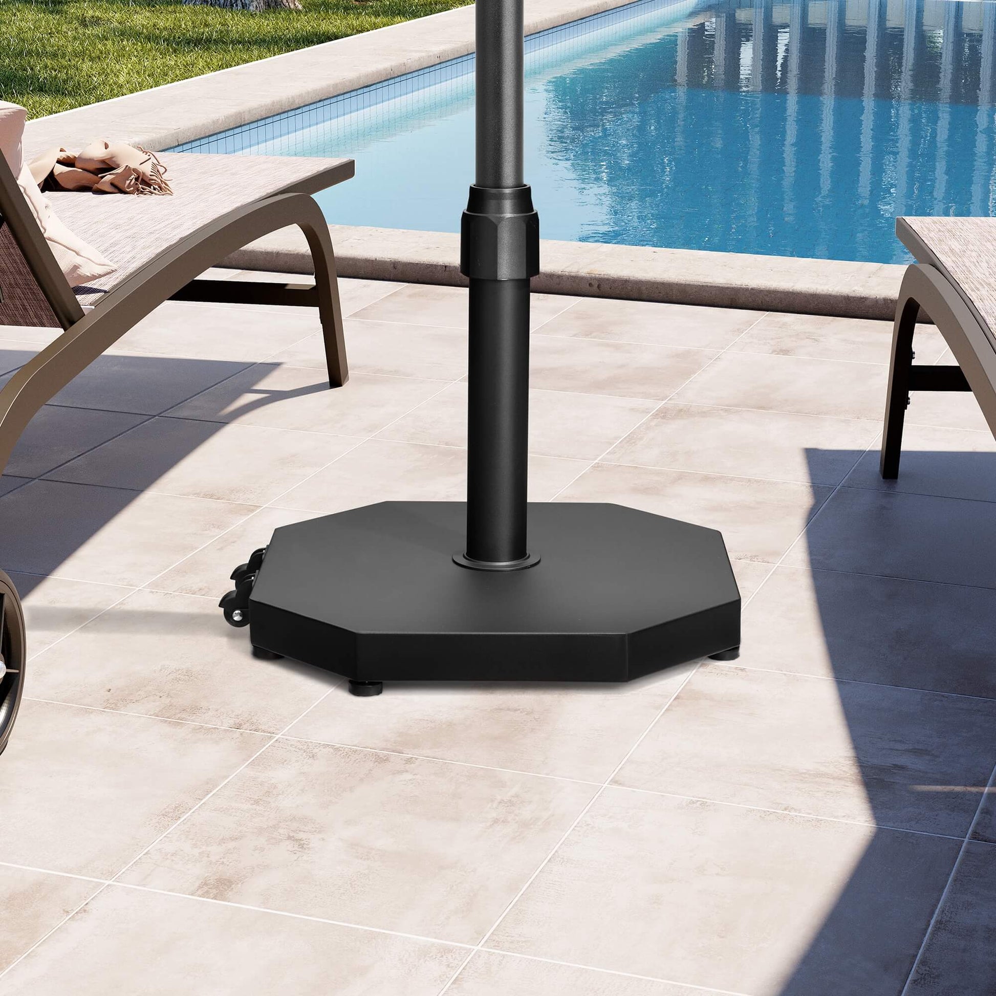 Black 40 lbs octagonal cement market umbrella base with wheels on a bright sunlit poolside patio.