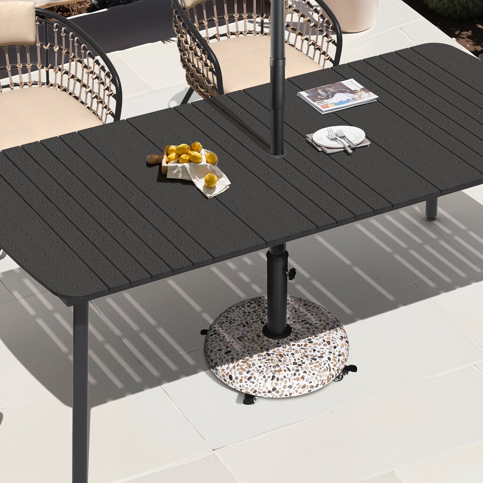 Round 45 lbs concrete cobble patio umbrella base with wheels placed under a black outdoor dining table.