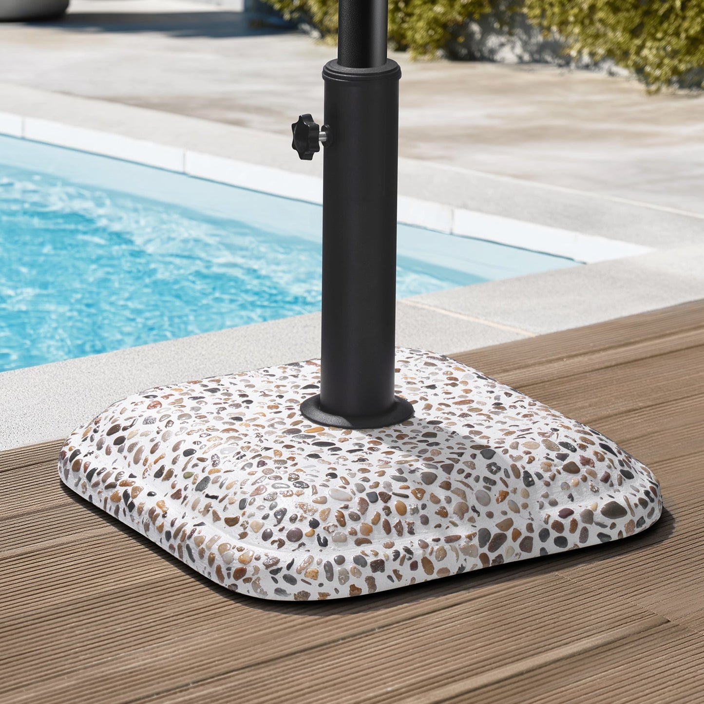 45 lbs cobble cement patio umbrella base without wheels standing on a poolside deck.